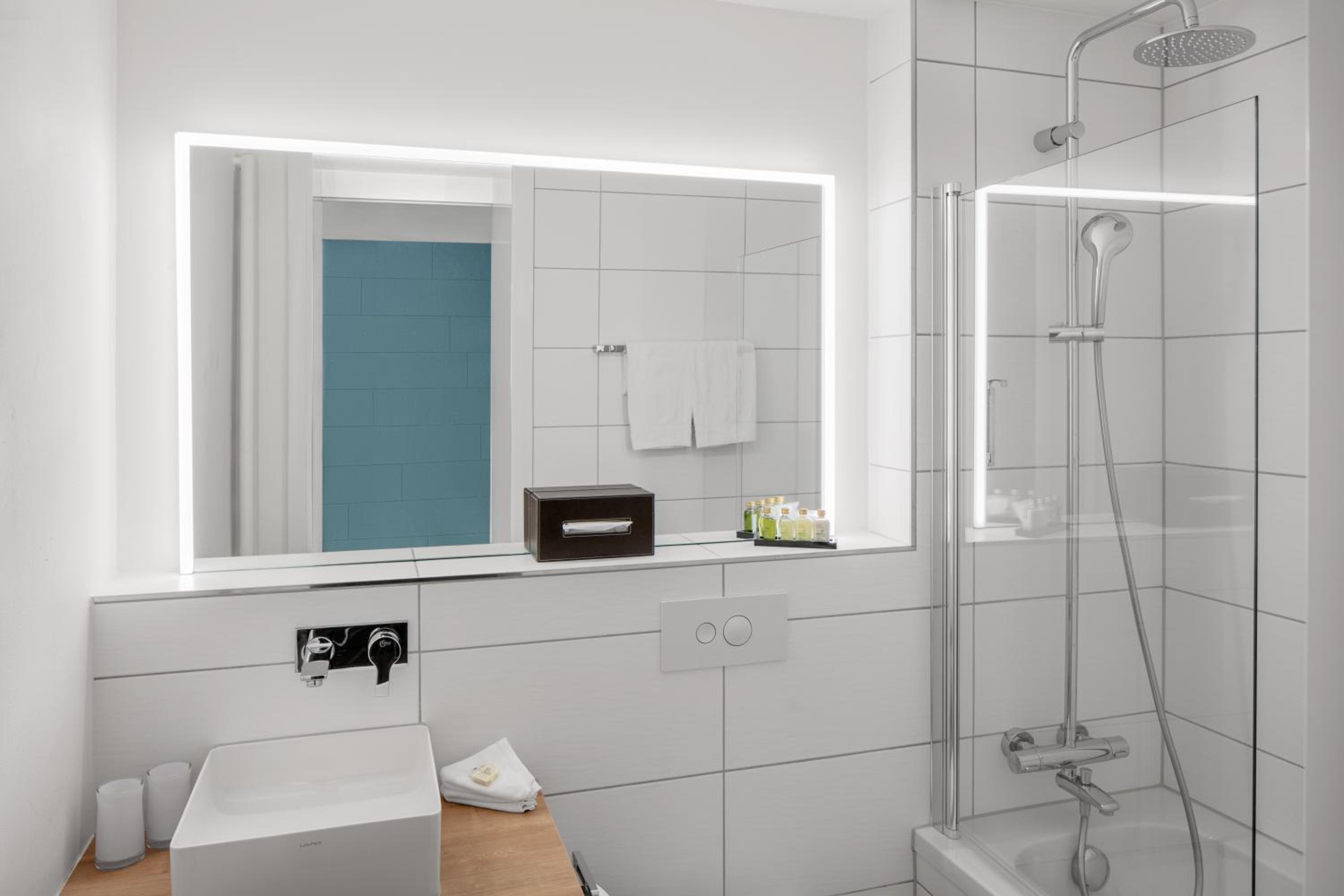 bathroom with a sink, mirror, and shower stall