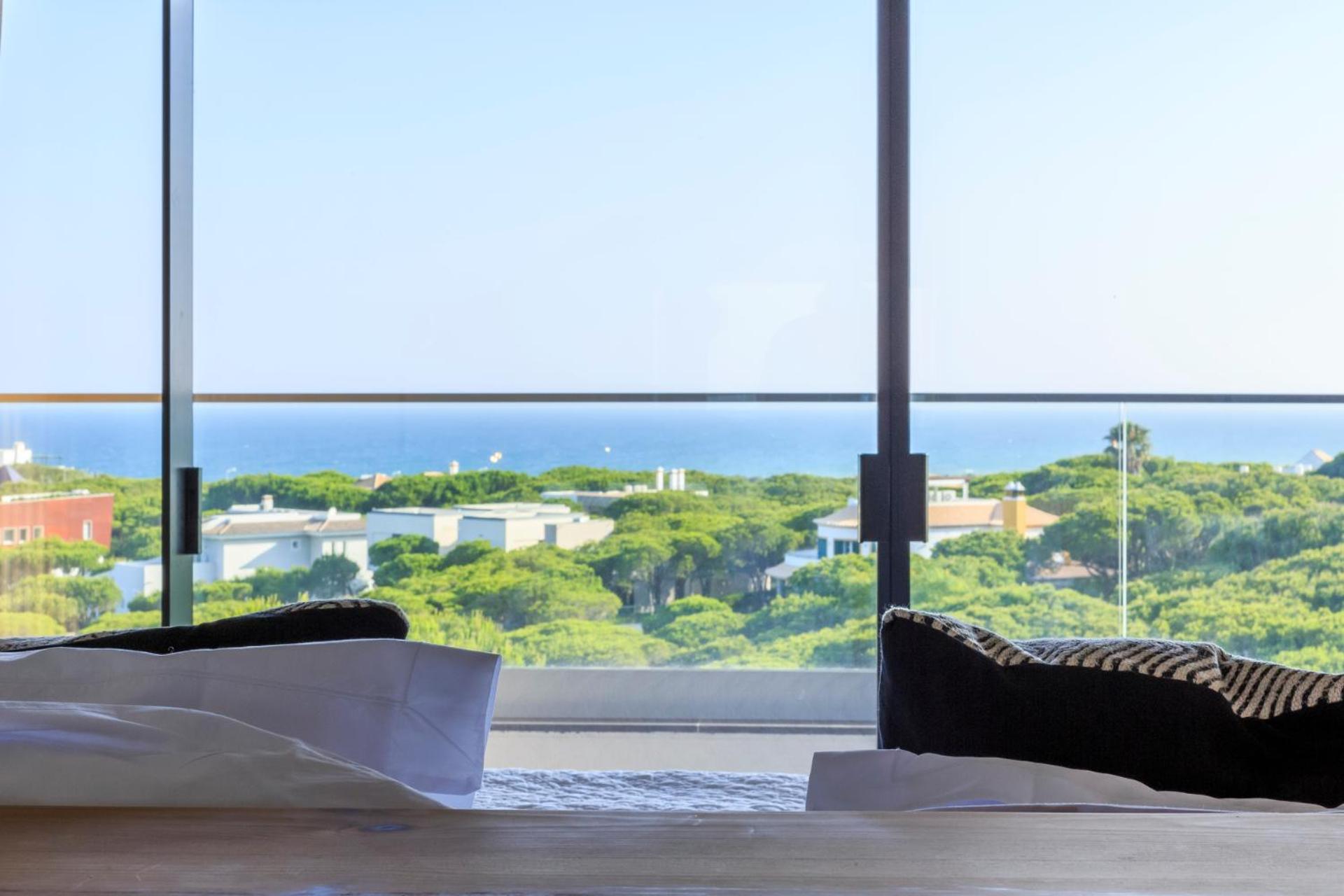 view out the window of a bedroom overlooking the ocean