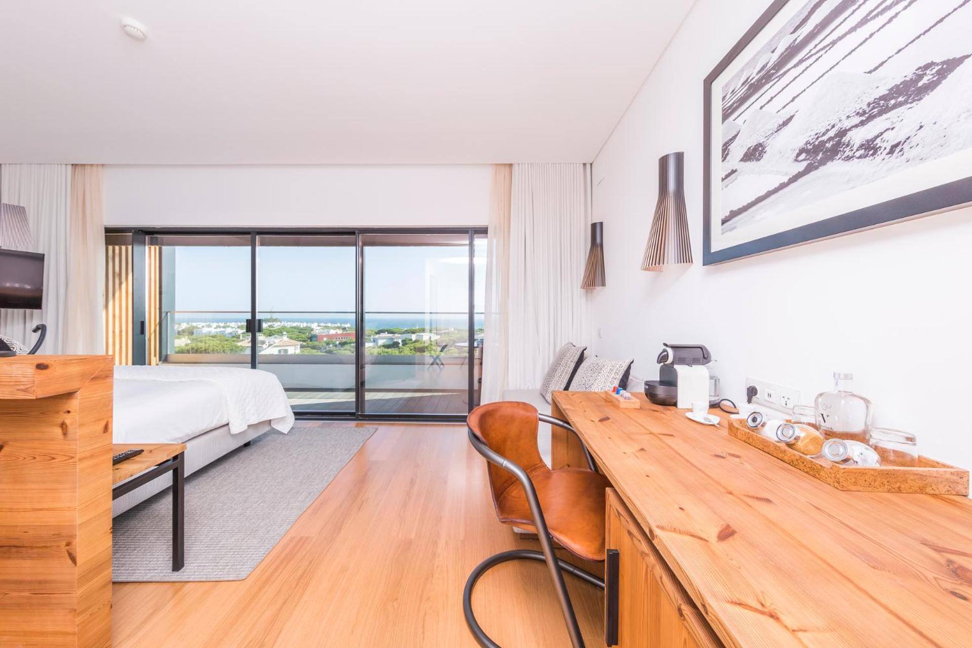 room with a bed, desk, chair and television