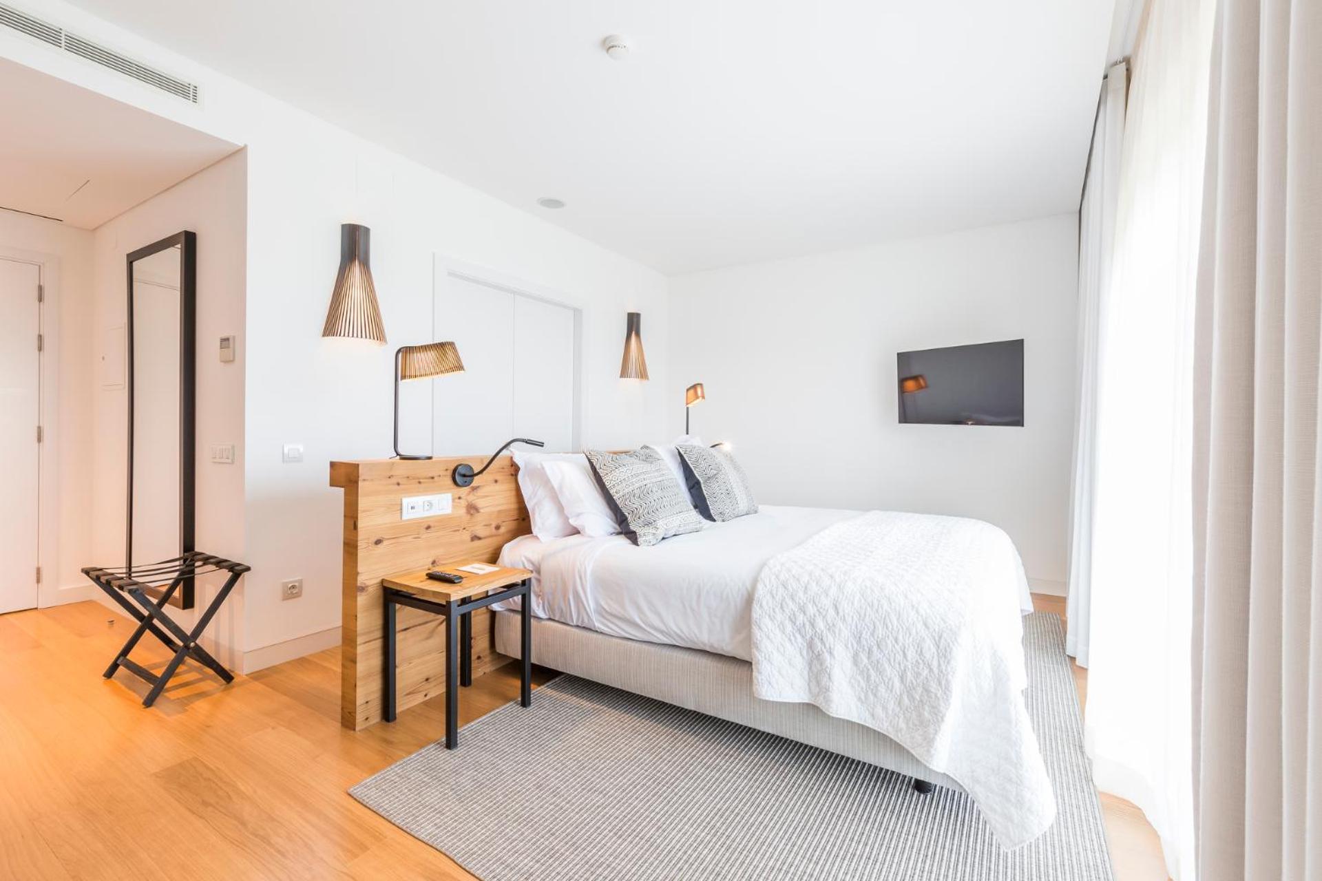 bedroom with a white bed and wood flooring?