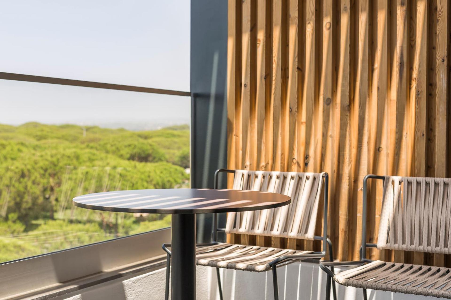 balcony with two chairs and a table in the foreground