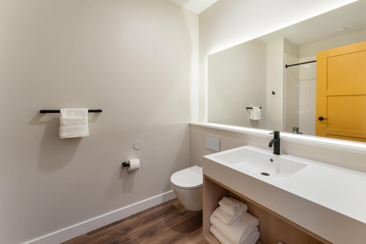 Modern bathroom with white sink, toilet, and mirror