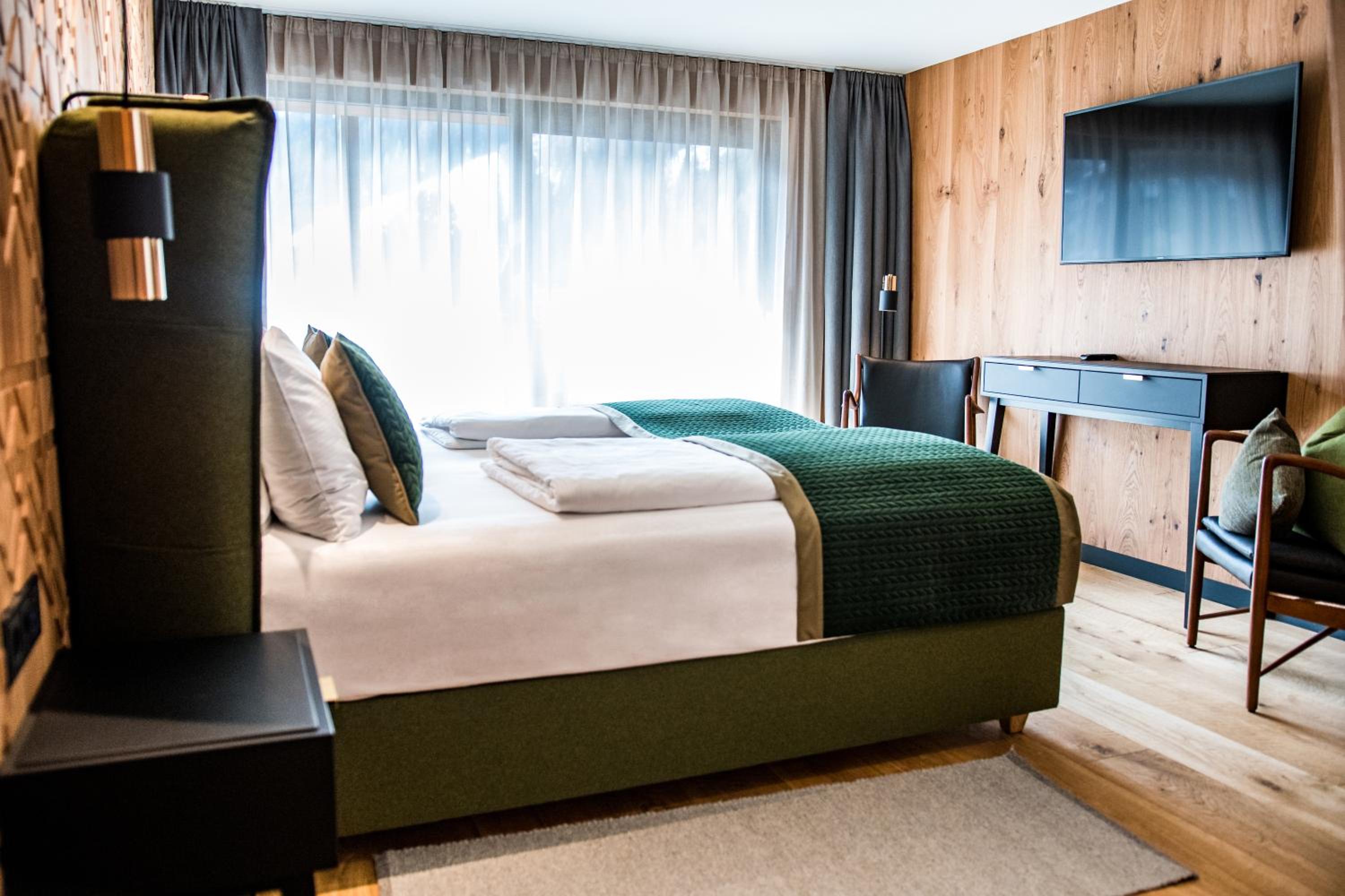 hotel room with a bed, desk, and television