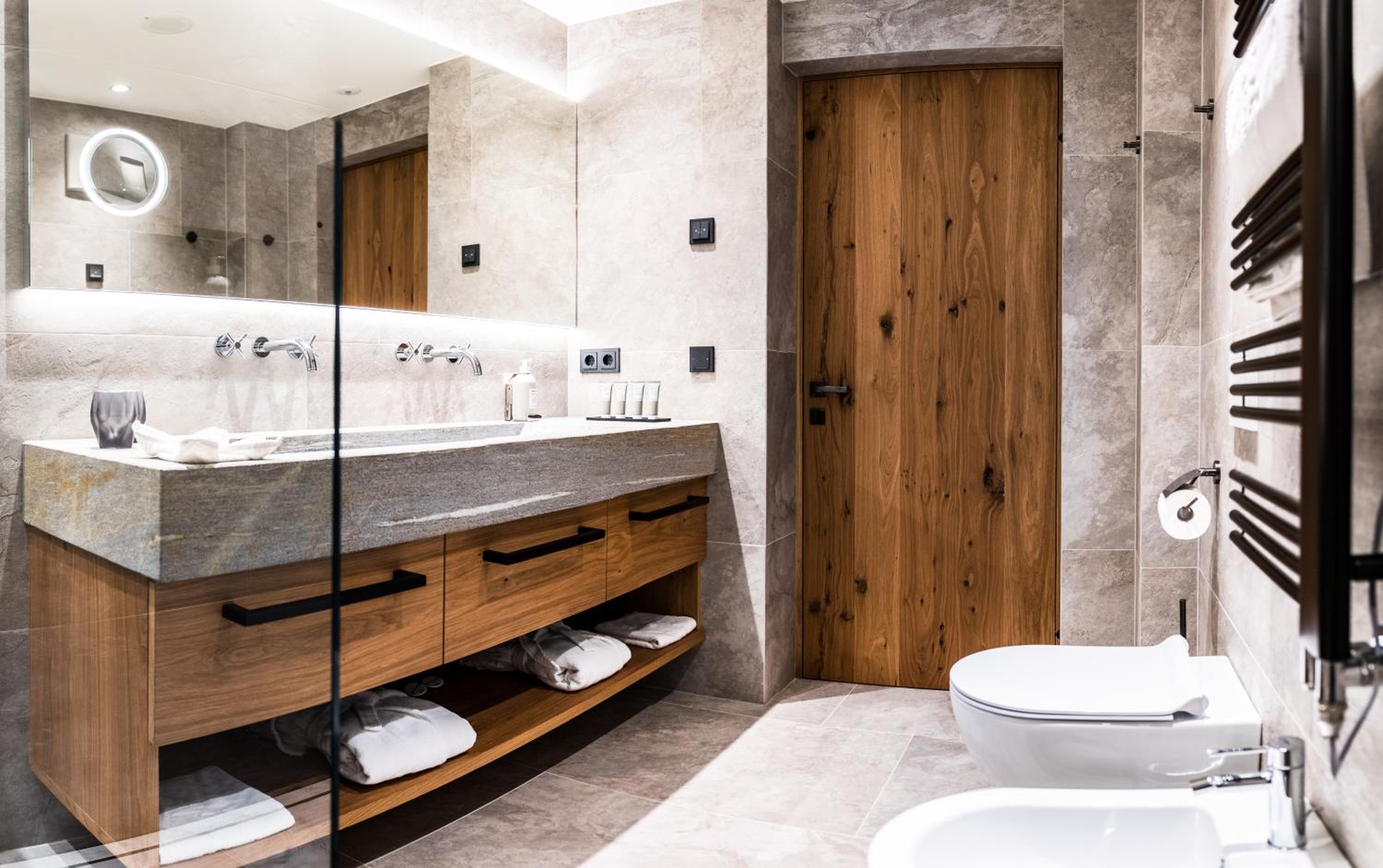 bathroom with two sinks, a toilet and a shower