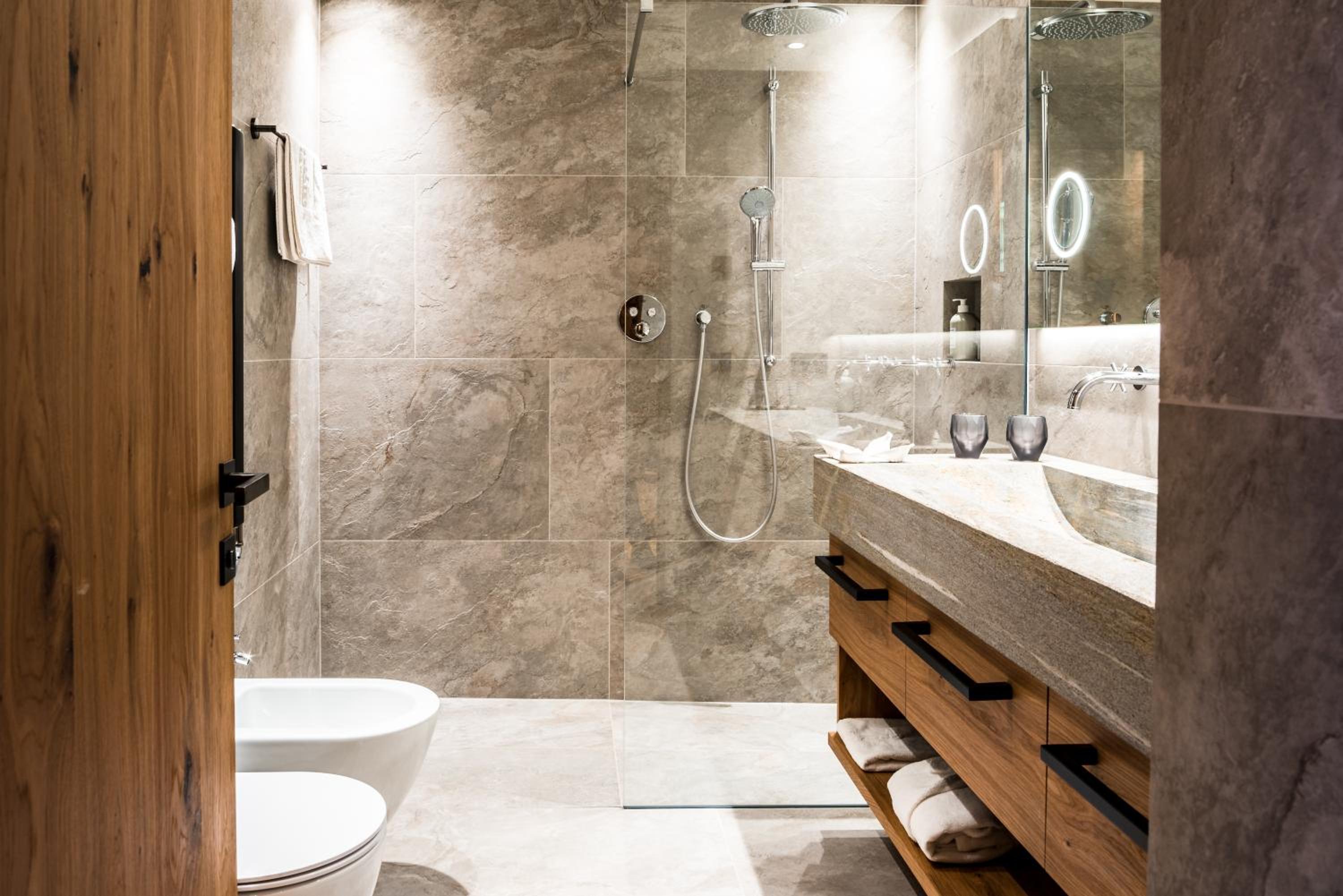 bathroom with a toilet, sink, and shower stall