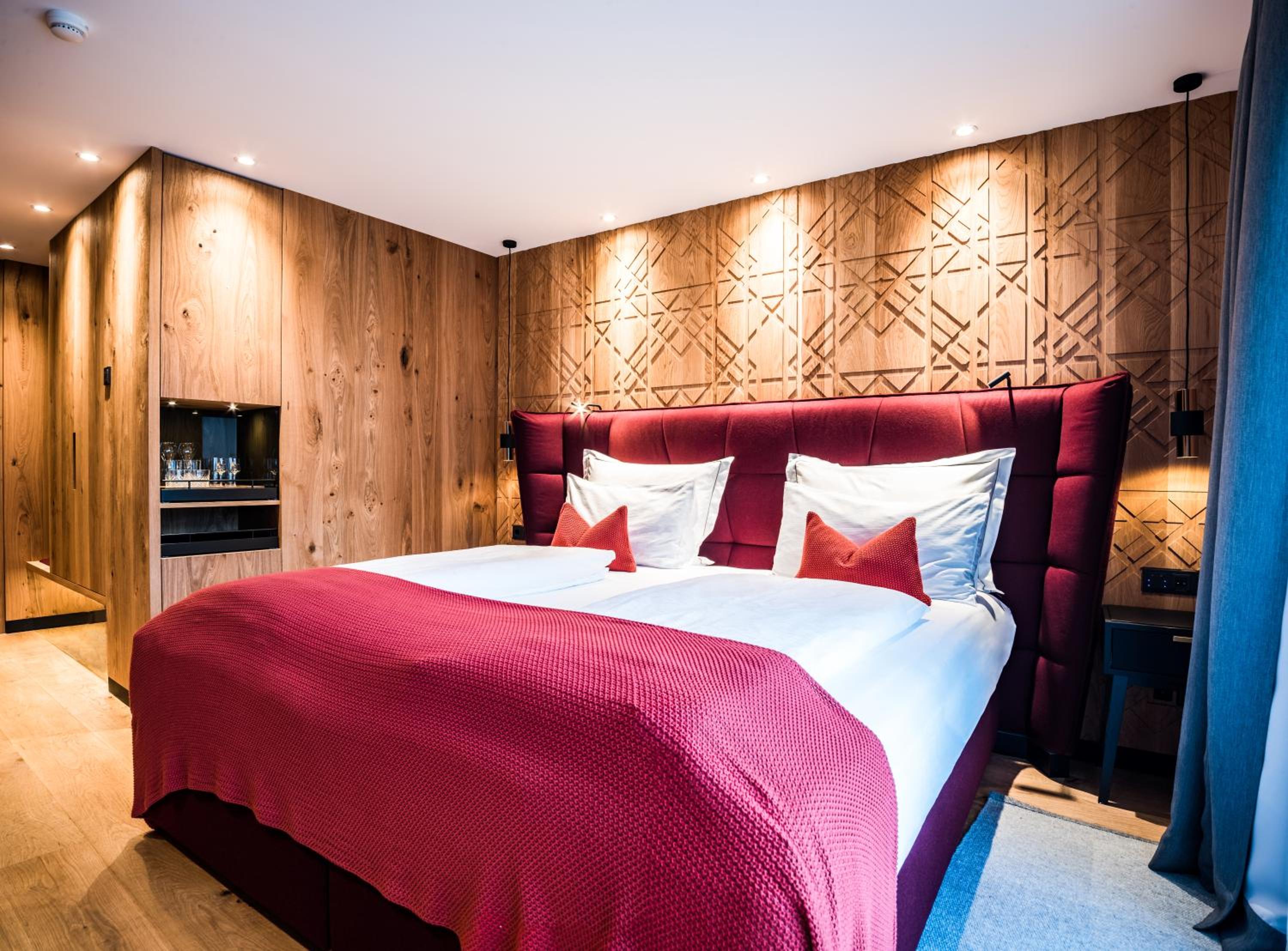 bedroom with wood paneling and red bedspread