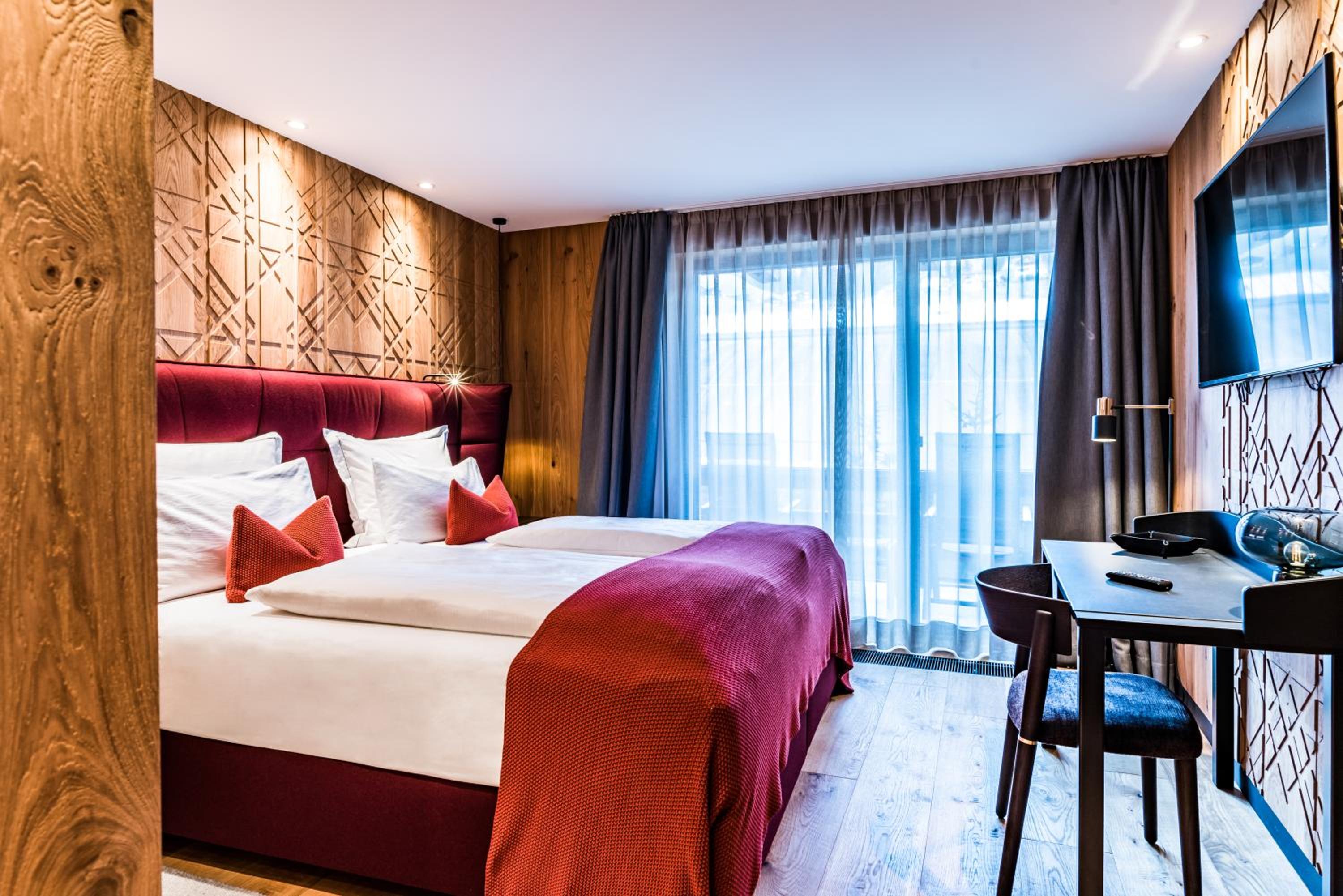 hotel room with a bed, desk, and television