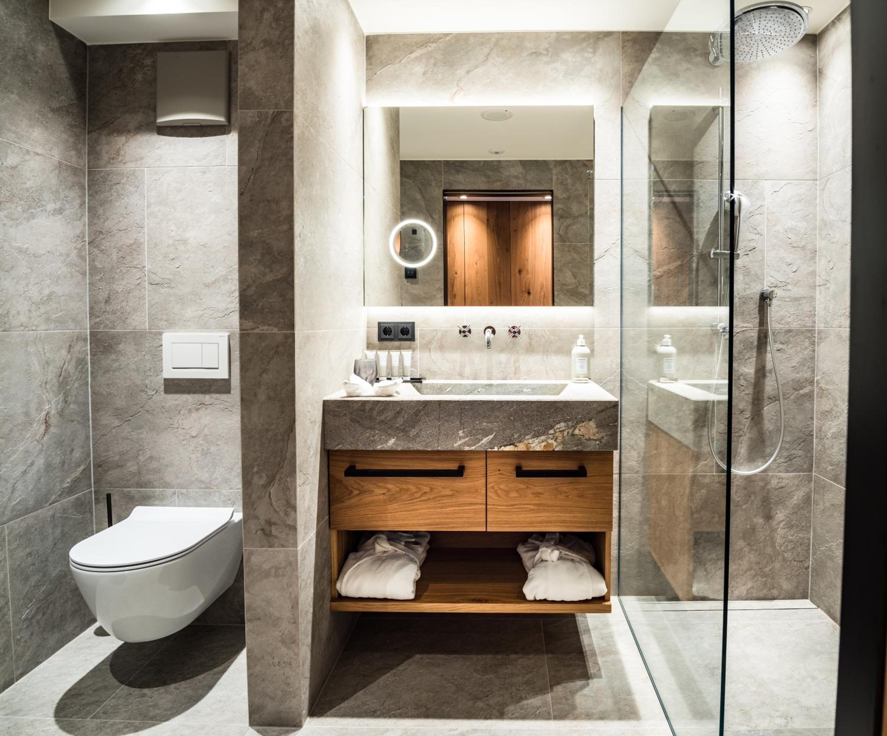 bathroom with a toilet, sink, and shower stall