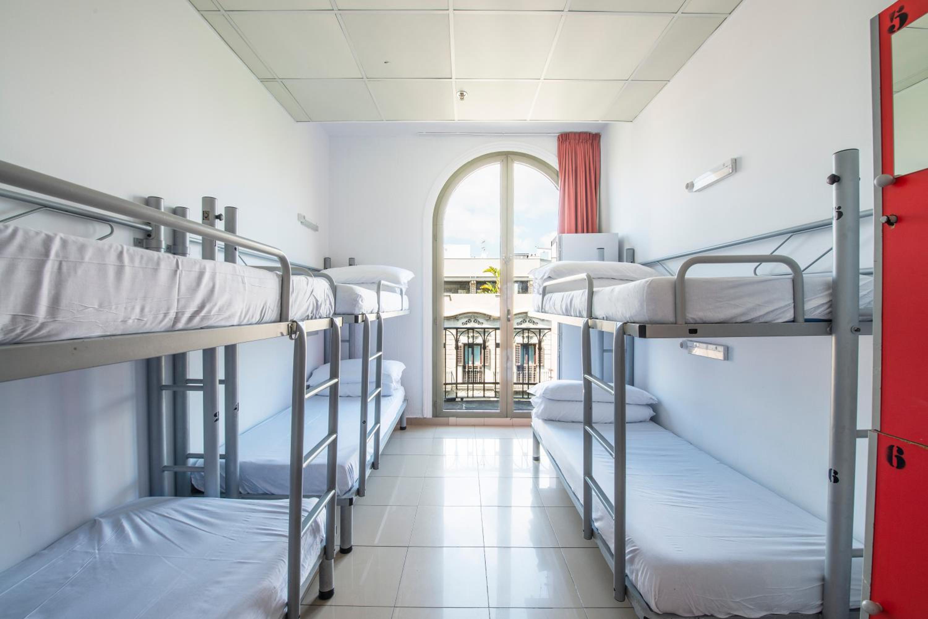 Cama en habitación compartida de 6 camas para mujeres con baño privado.