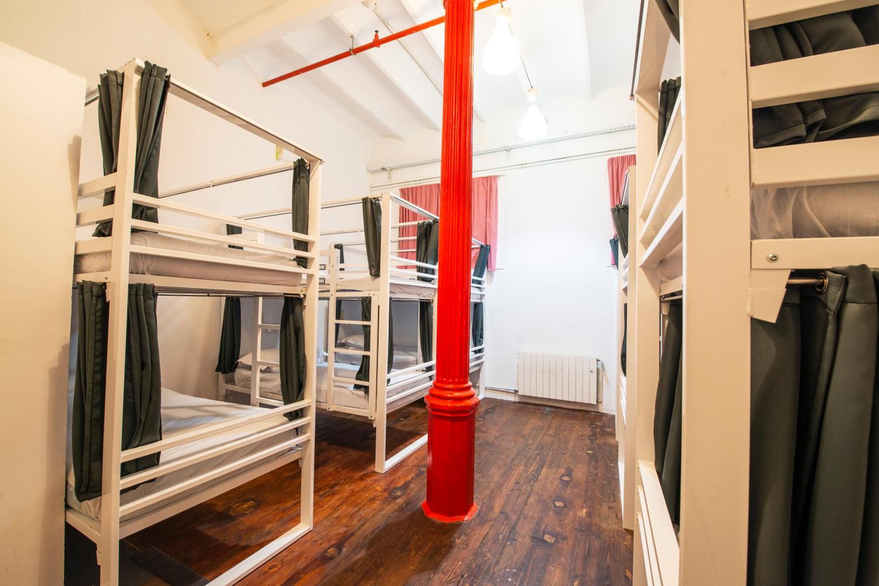 Cama en una habitación compartida mixta de 12 camas con baño compartido.