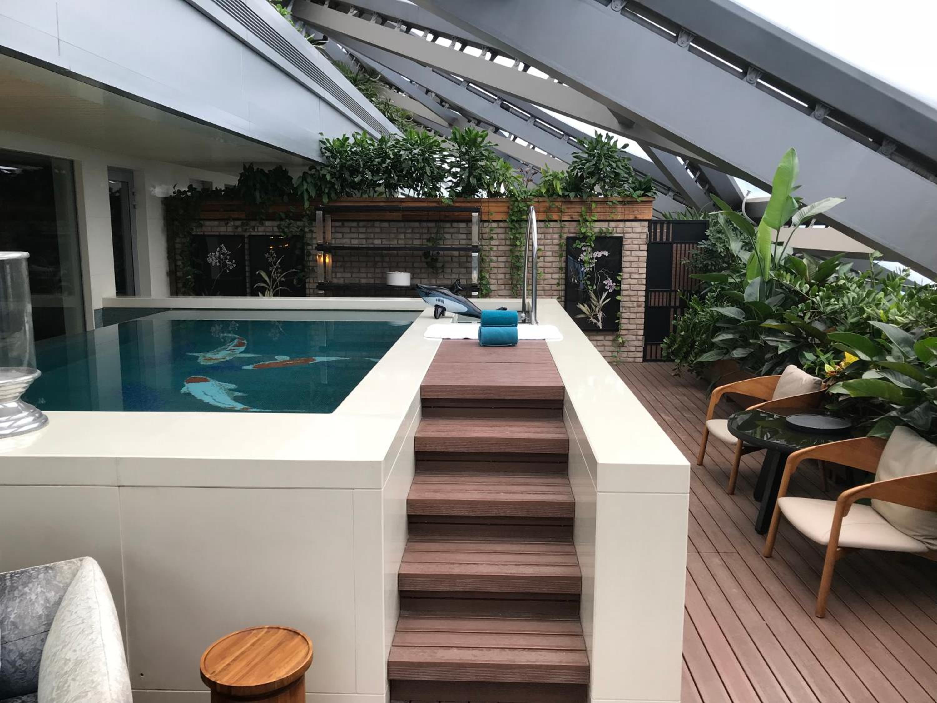 pool in the middle of a deck with steps leading up to it