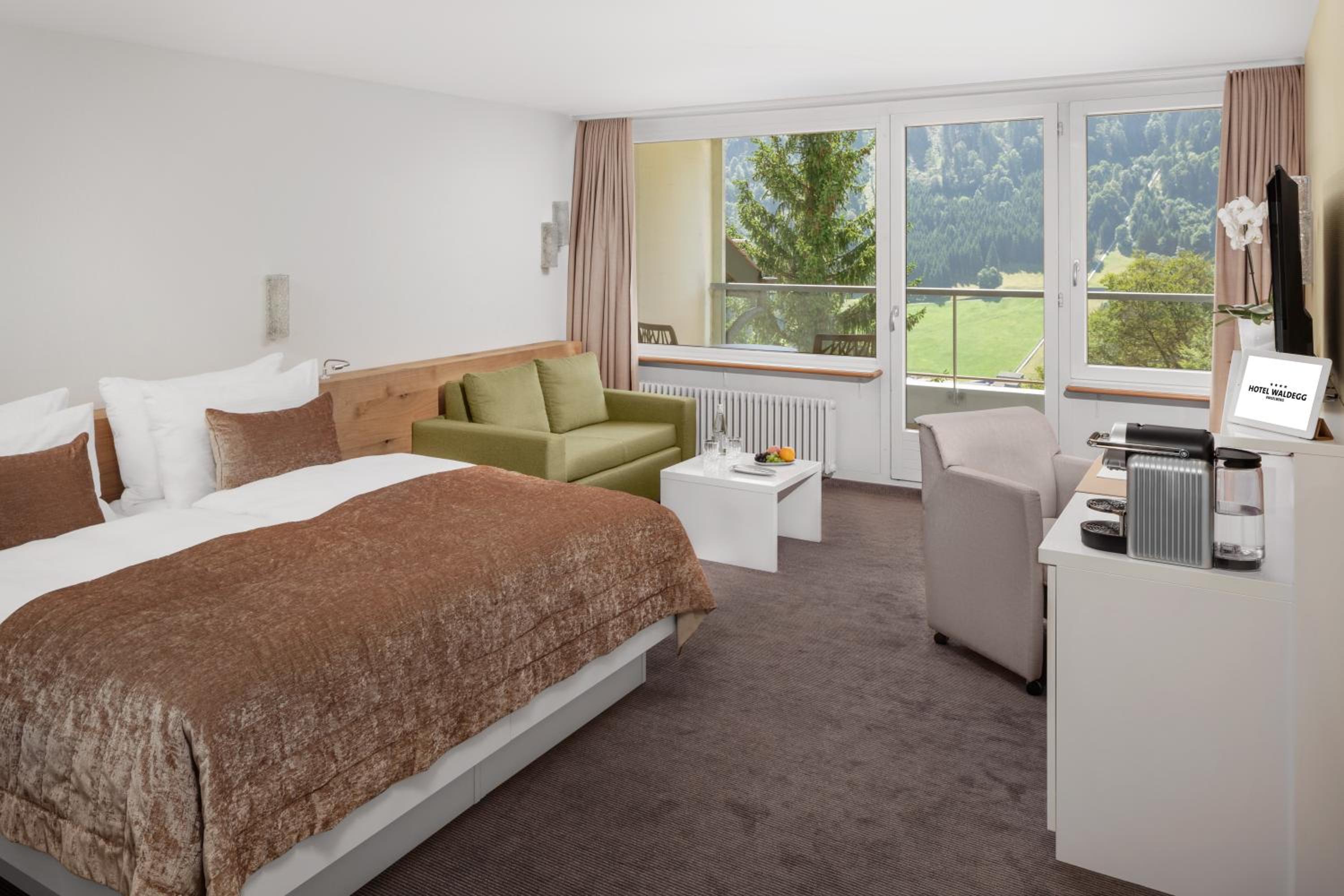hotel room with a bed, couch, and television