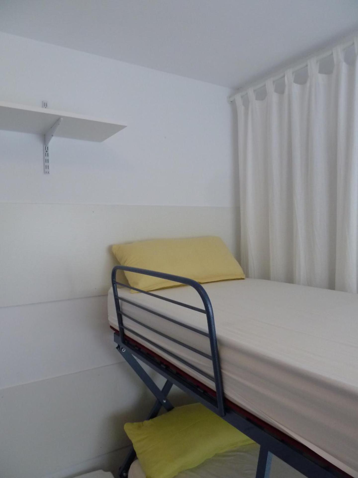 Cama individual en dormitorio compartido de 10 camas.