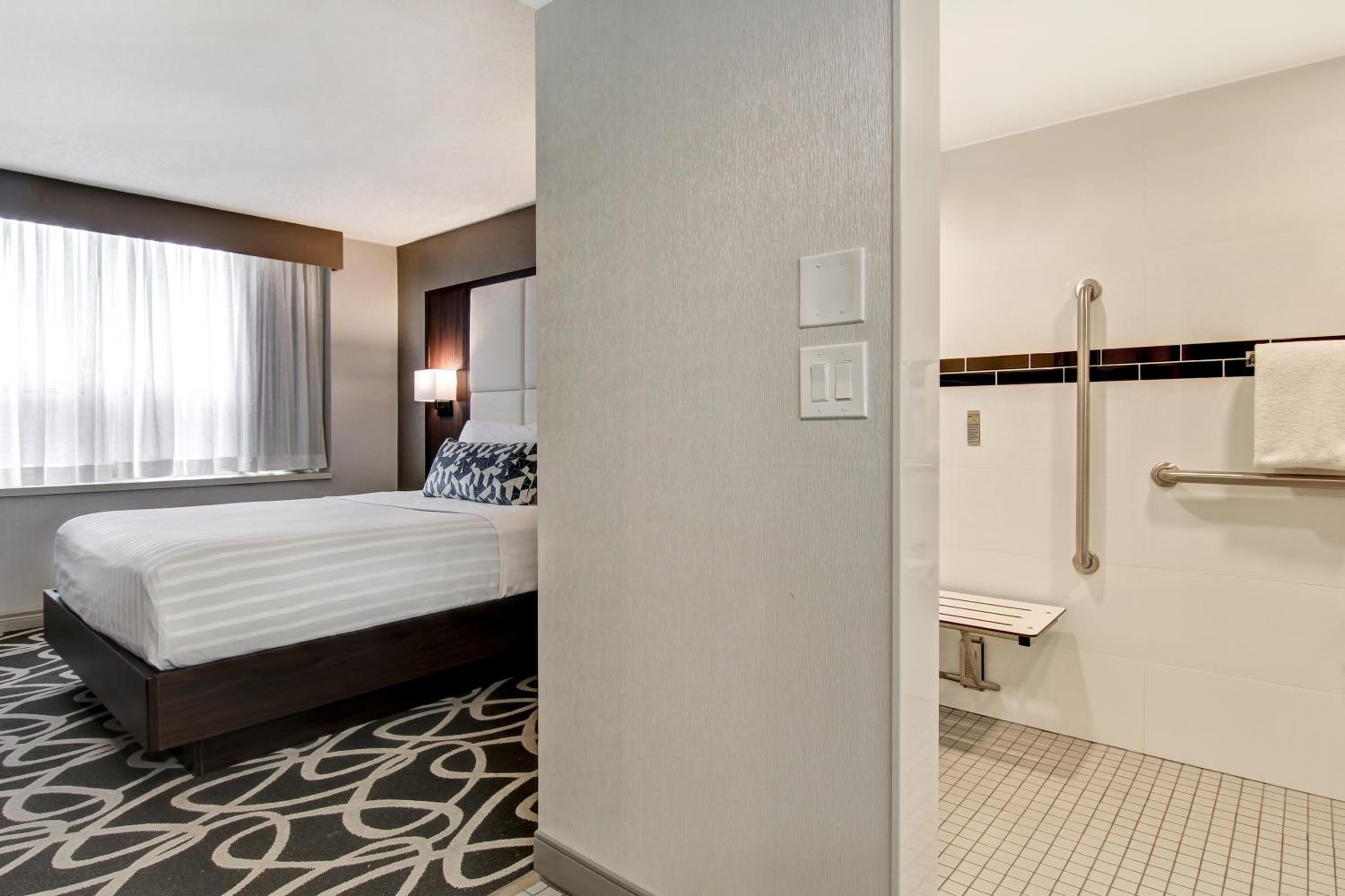 hotel room with a large bed and a walk in shower