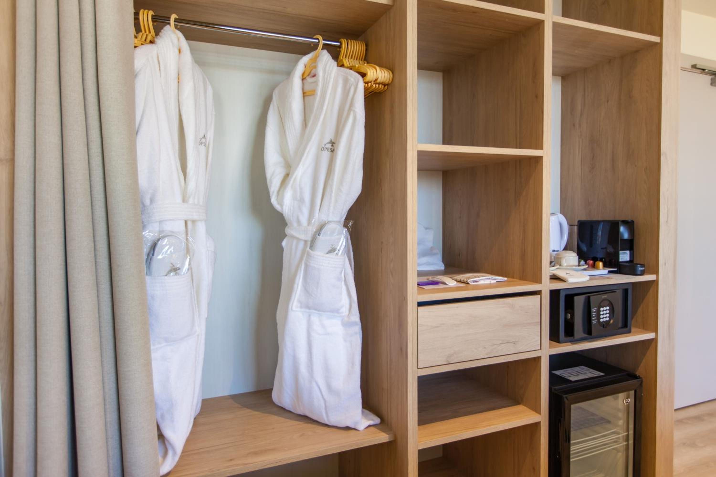 walk - in closet with two robes hanging on it