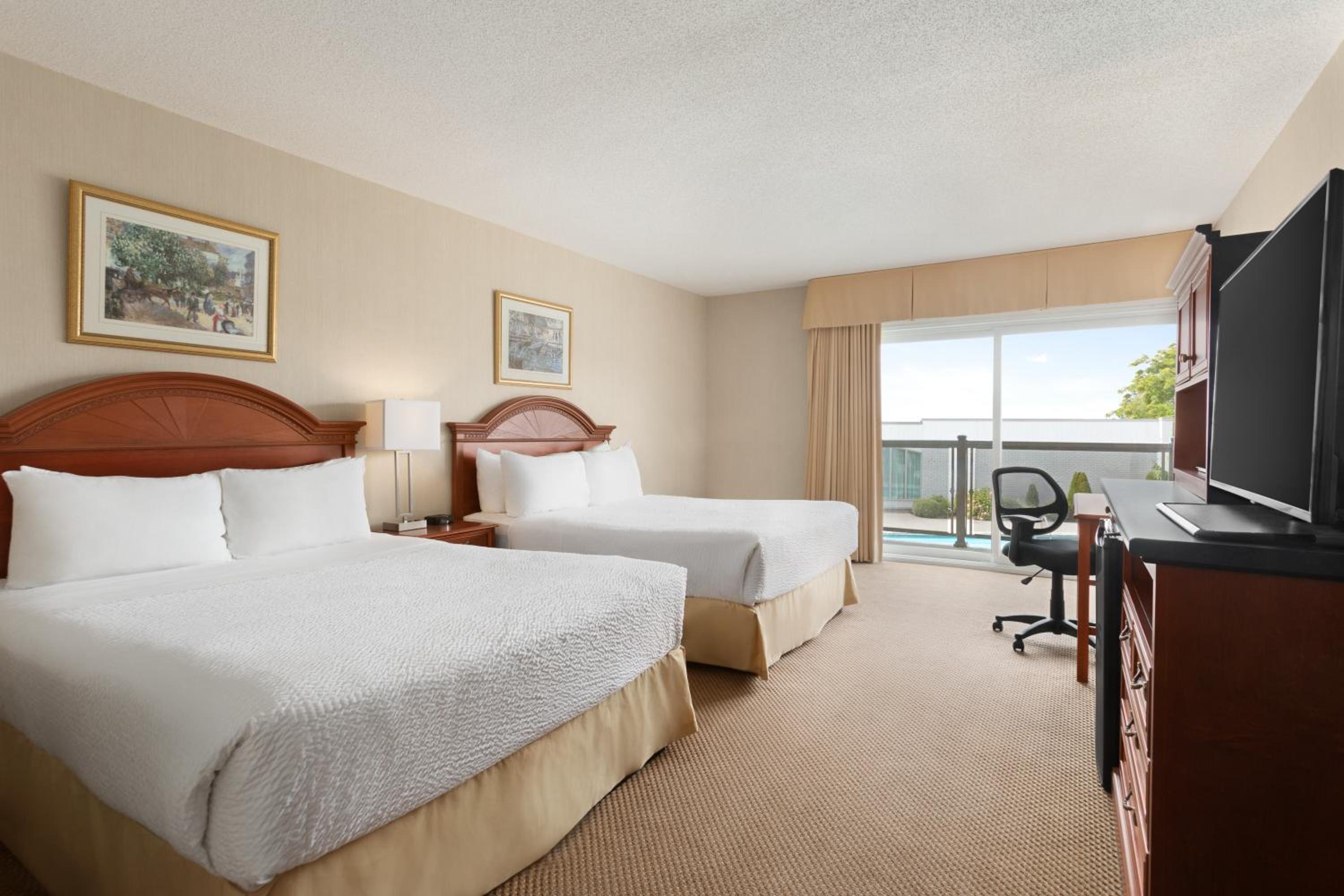 hotel room with two beds and a flat screen tv