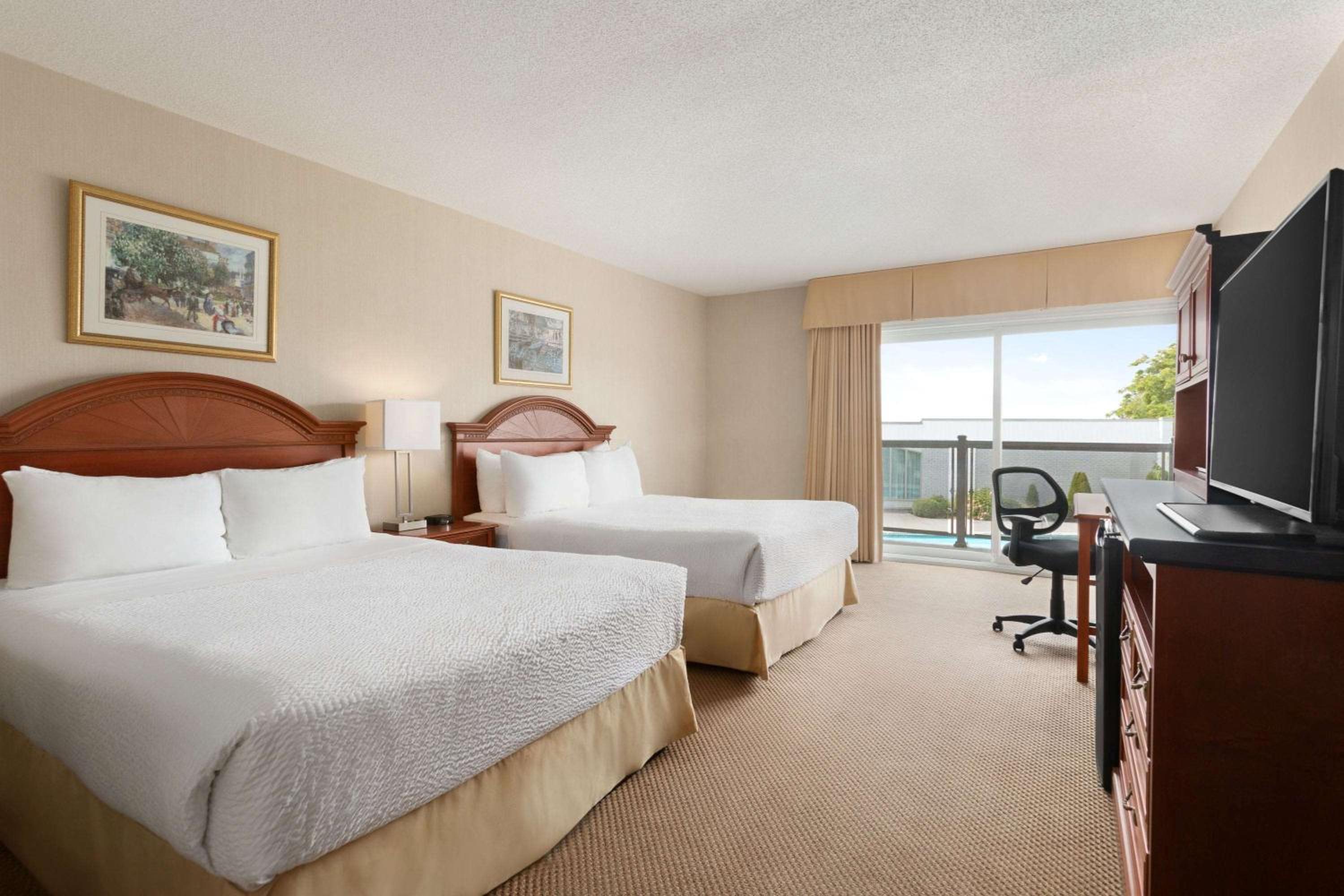 hotel room with two beds and a flat screen tv