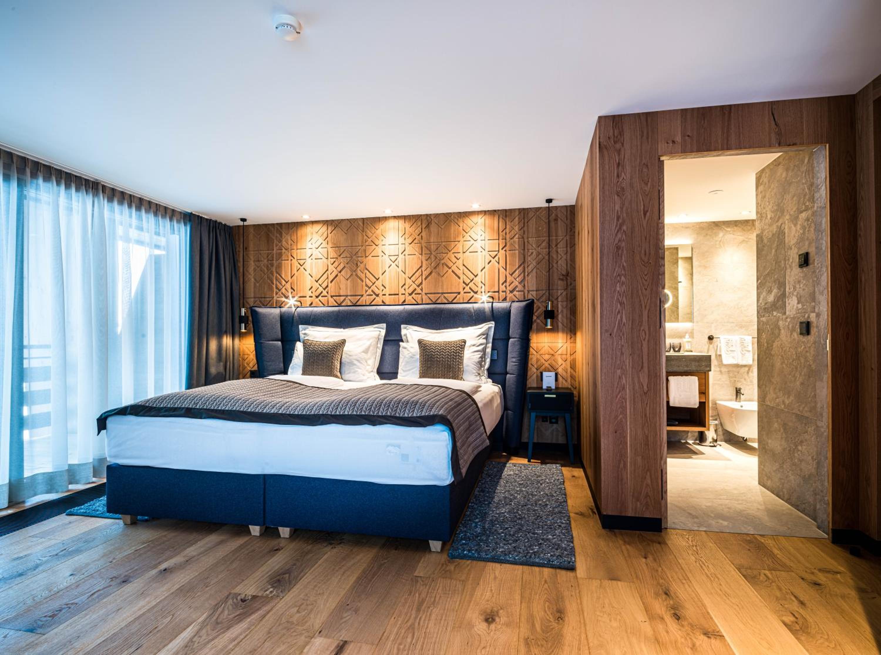hotel room with a large bed and wooden paneled walls