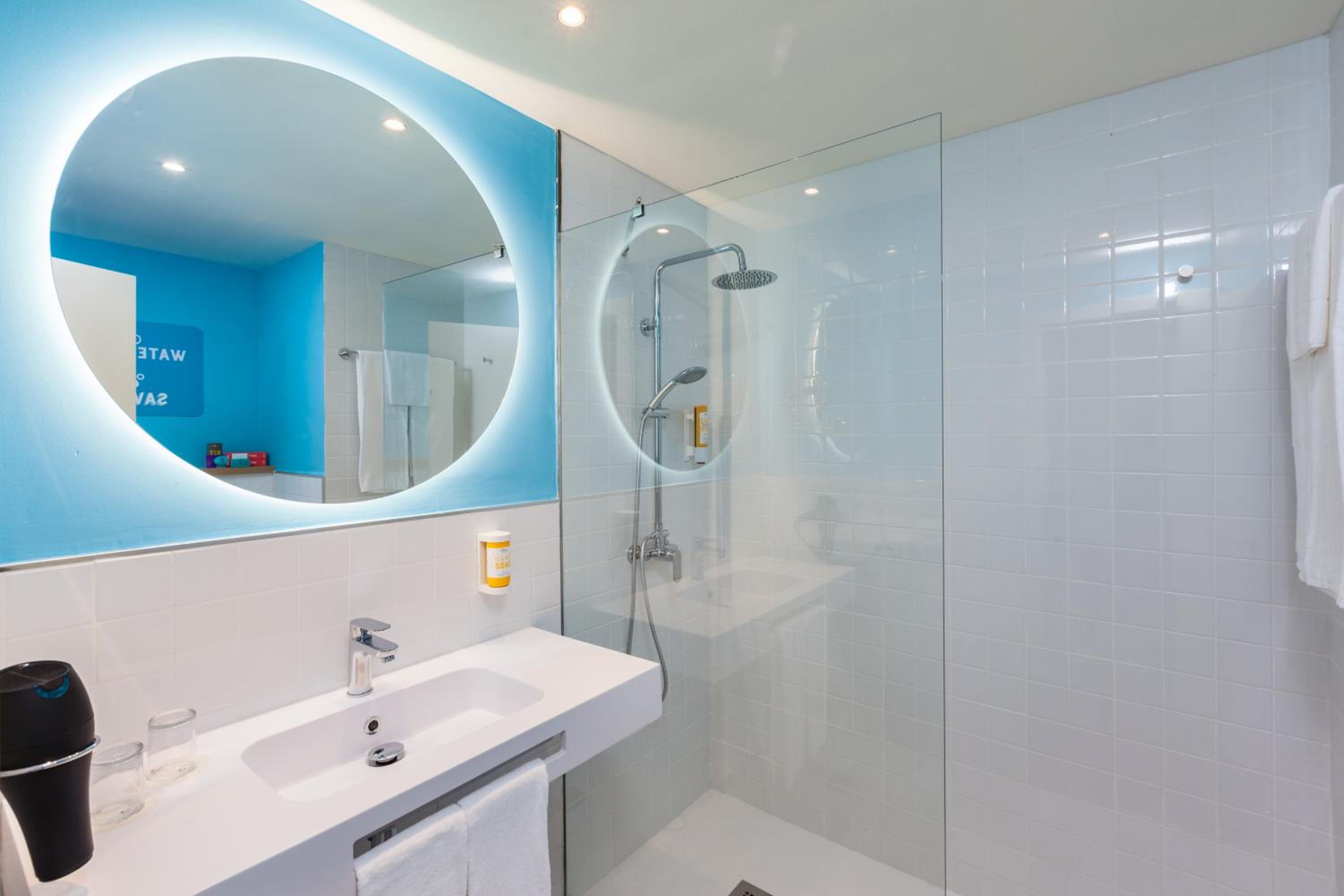 bathroom with a shower, sink, mirror and towel rack