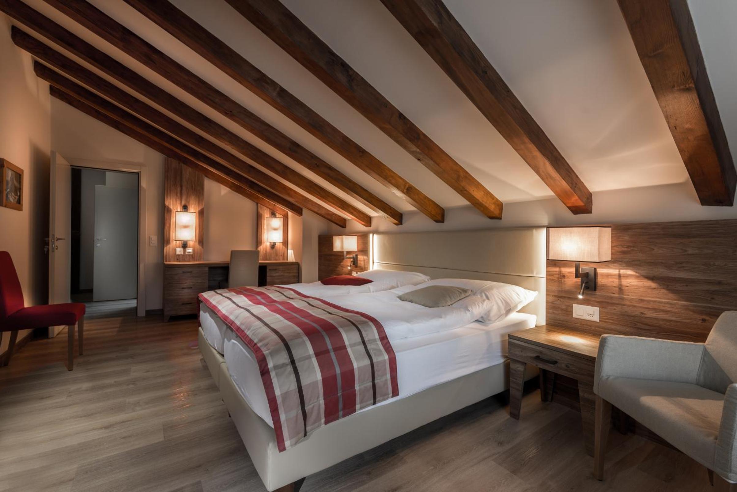 photo of a bedroom with a bed and two chairs