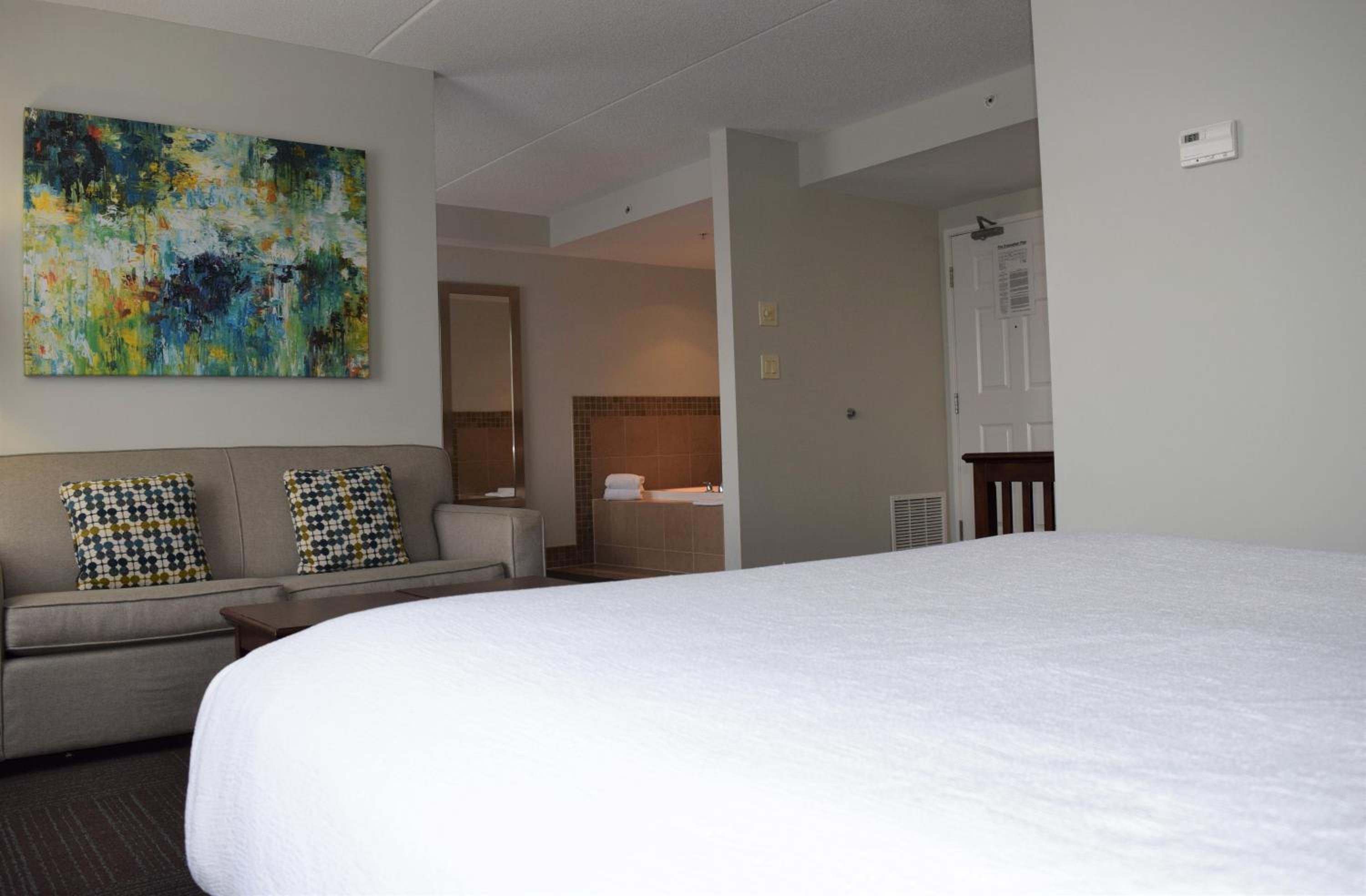 bedroom with a couch and a painting on the wall