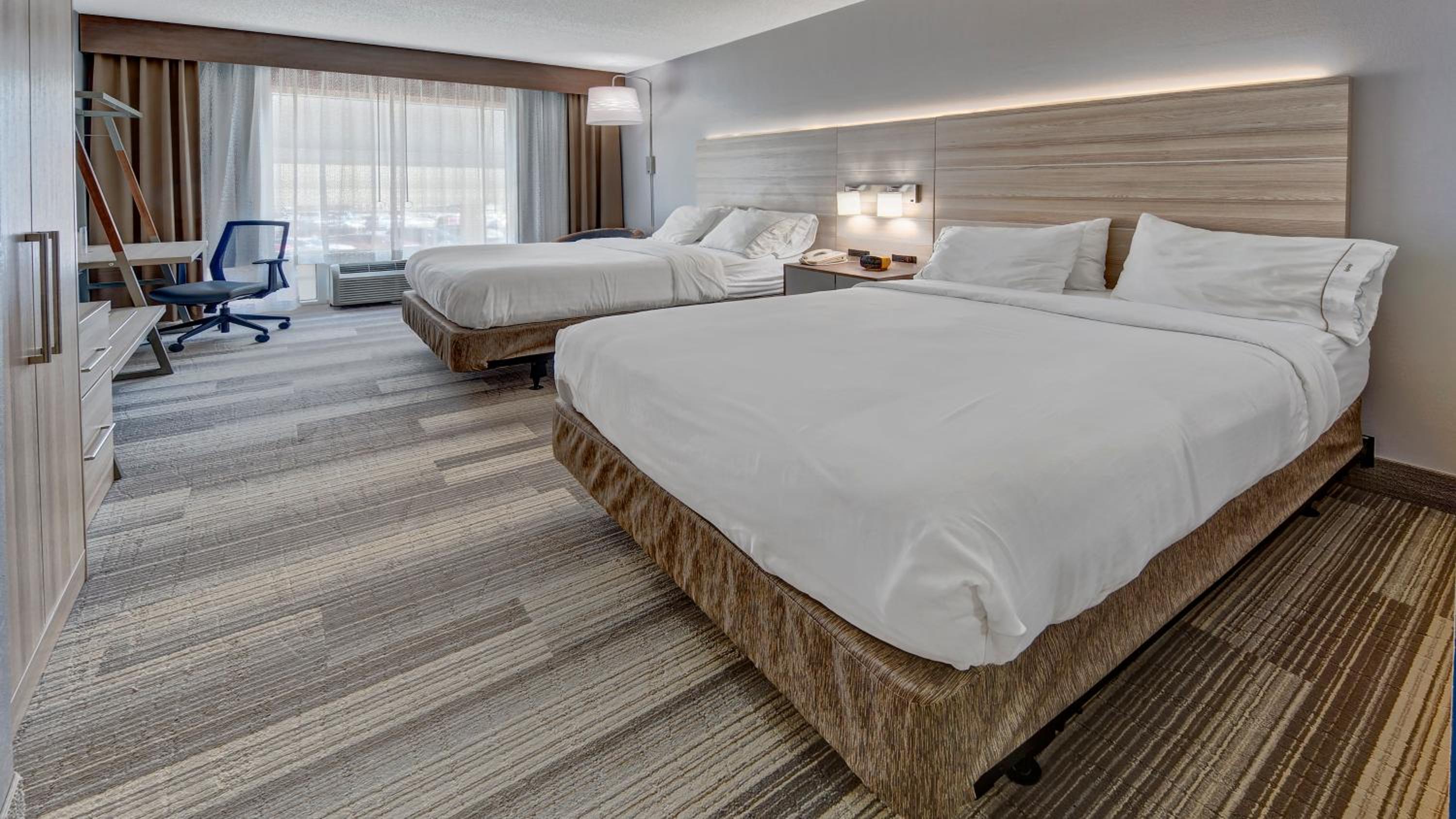 hotel room with two beds and a desk in the corner
