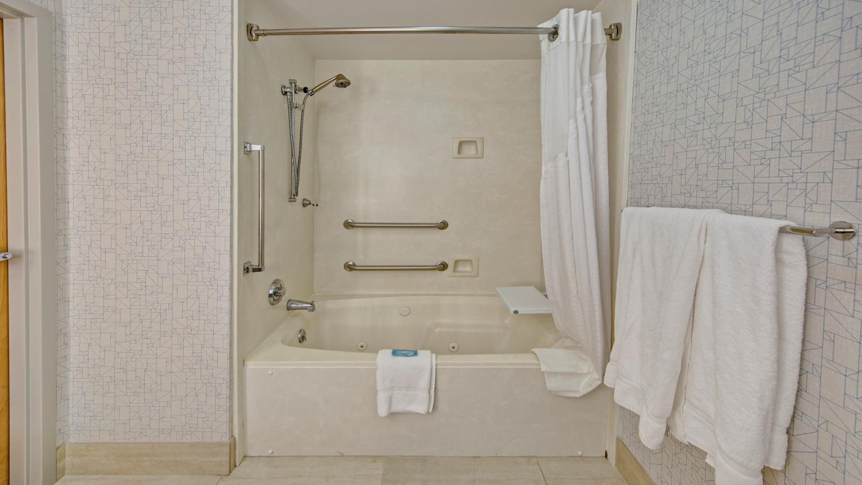 bathroom with a bathtub, shower curtain, and towel rack