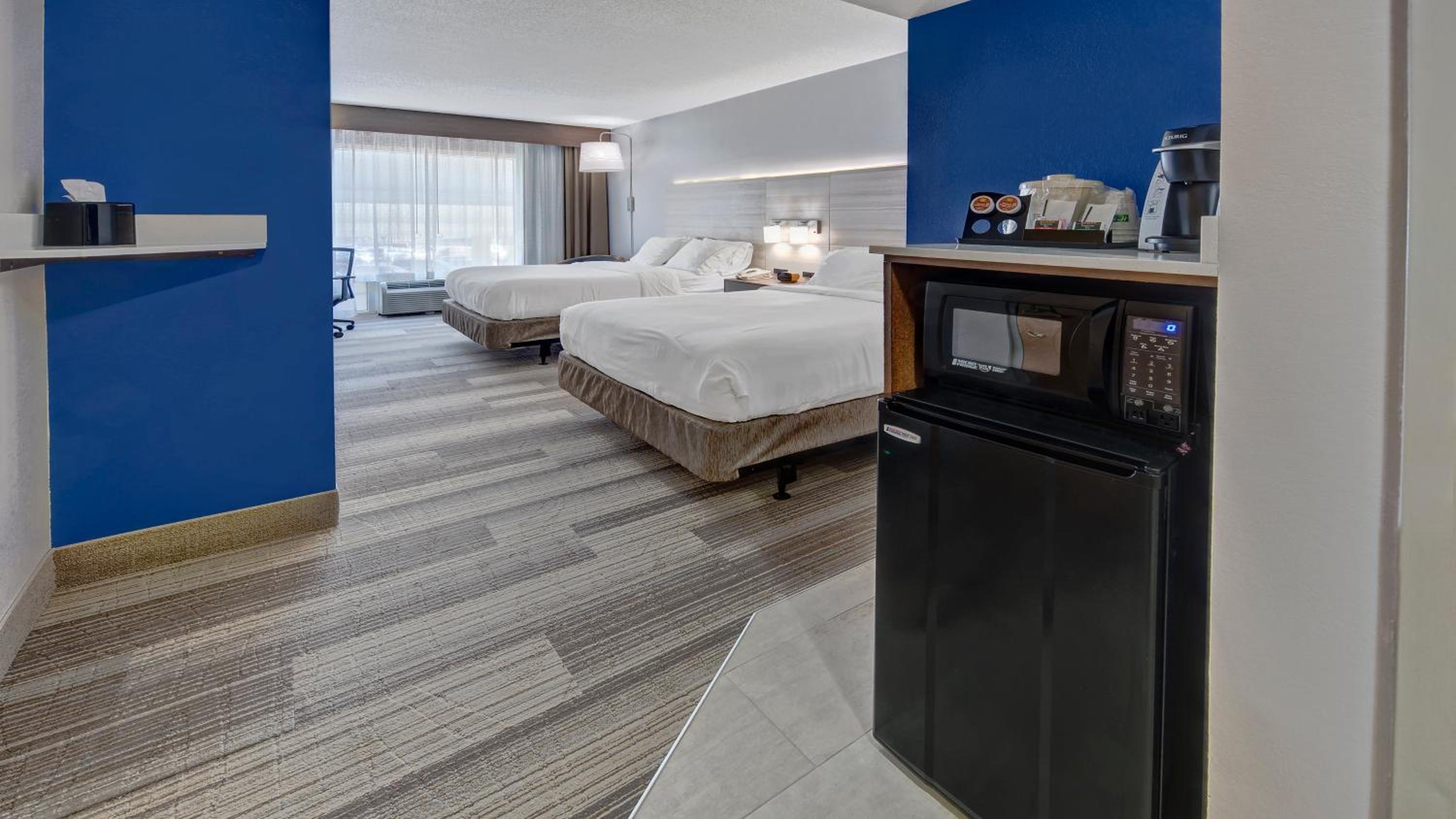 hotel room with two queen beds and a mini fridge