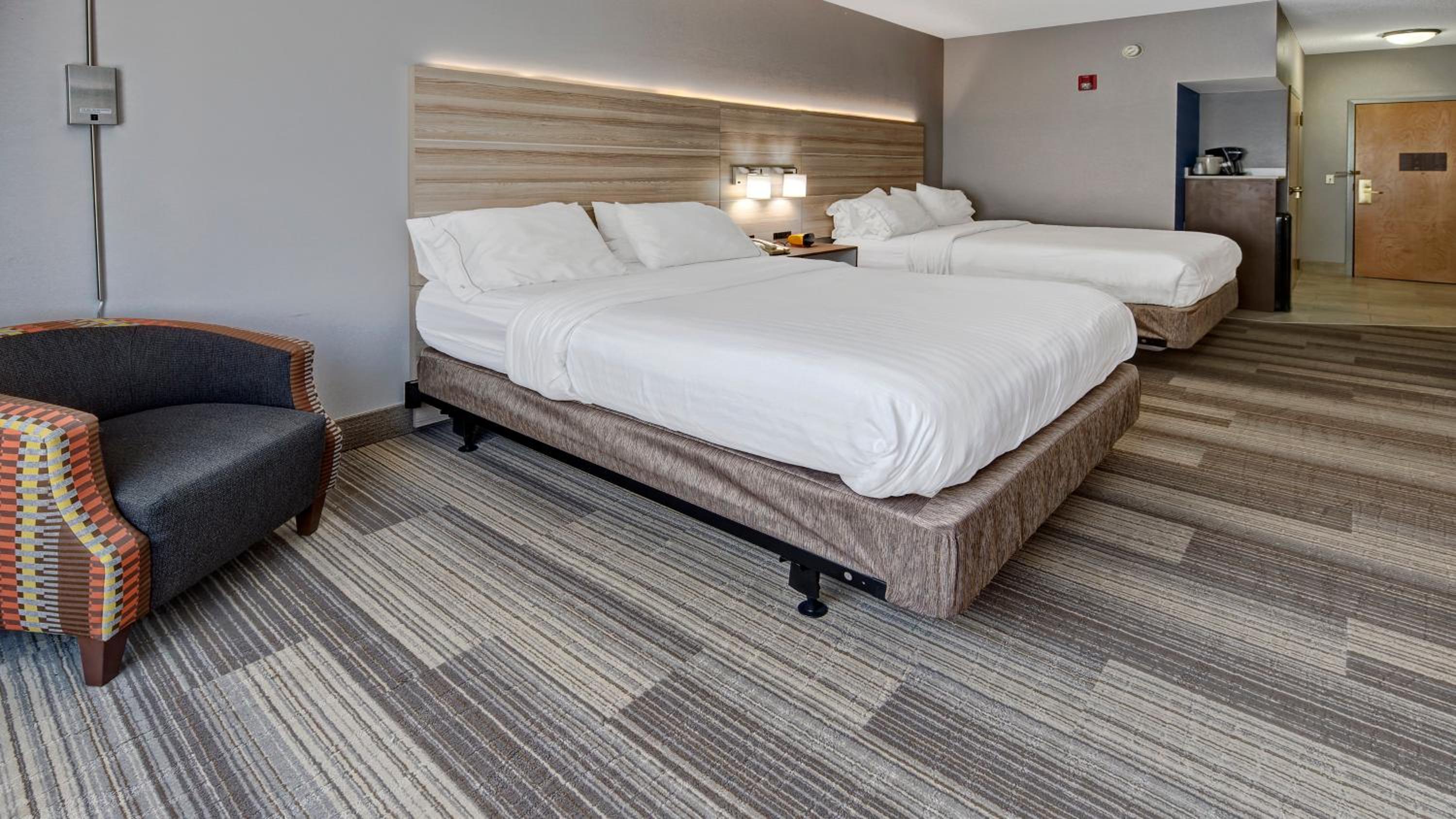 hotel room with two beds and a chair in it