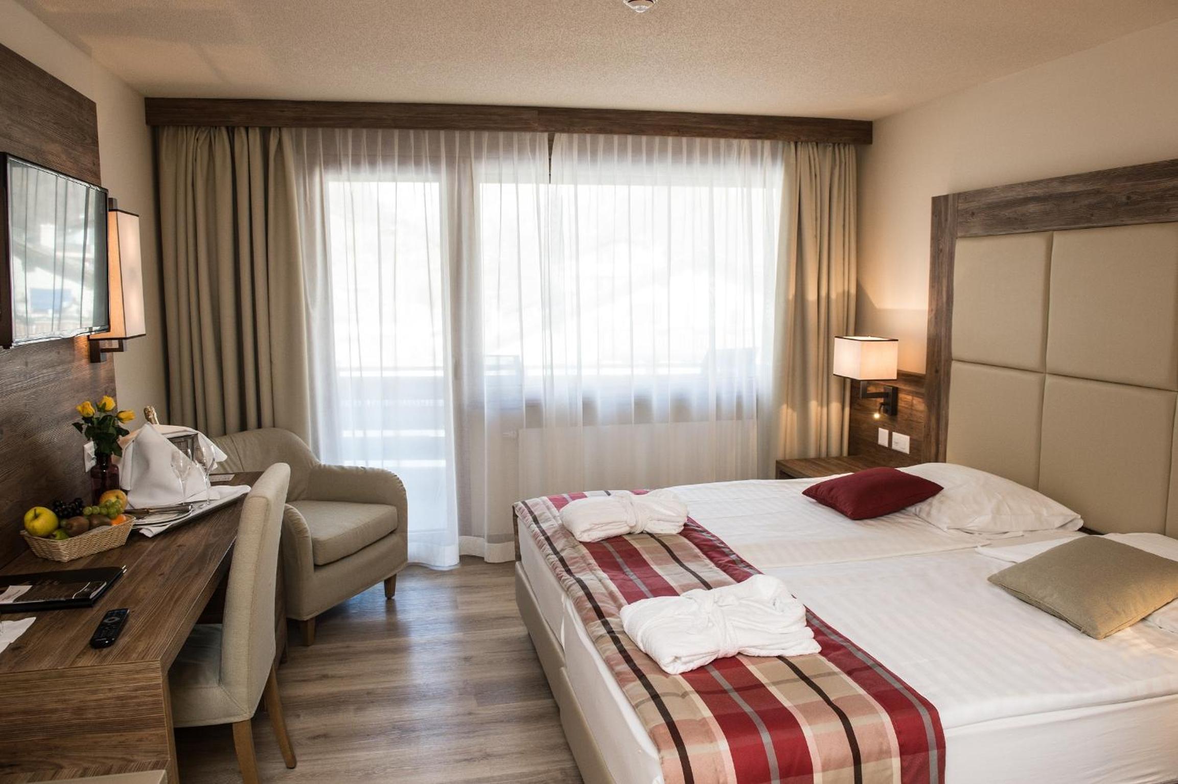 hotel room with a bed, desk, and chair