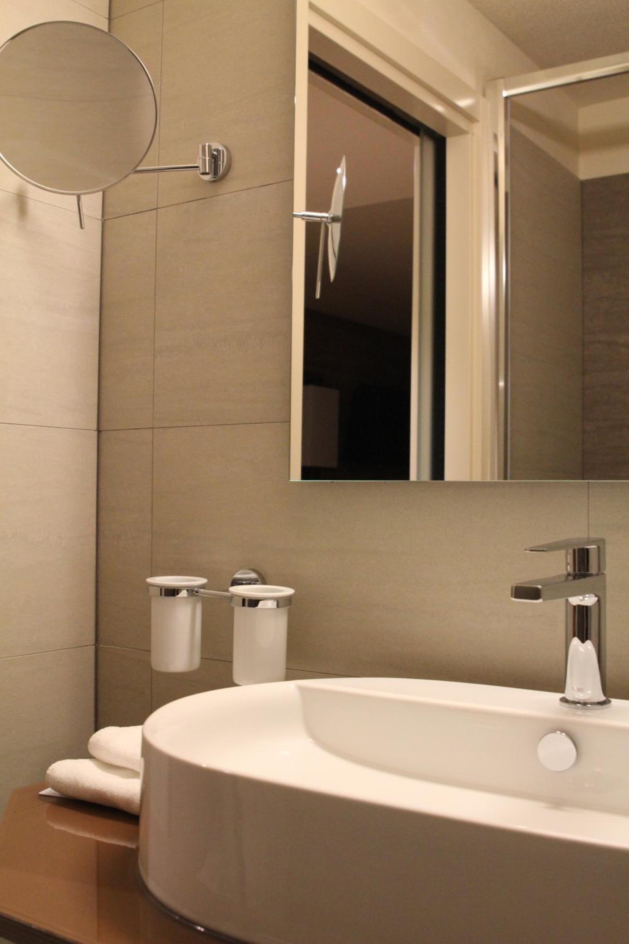 bathroom with a sink, mirror and soap dispenser