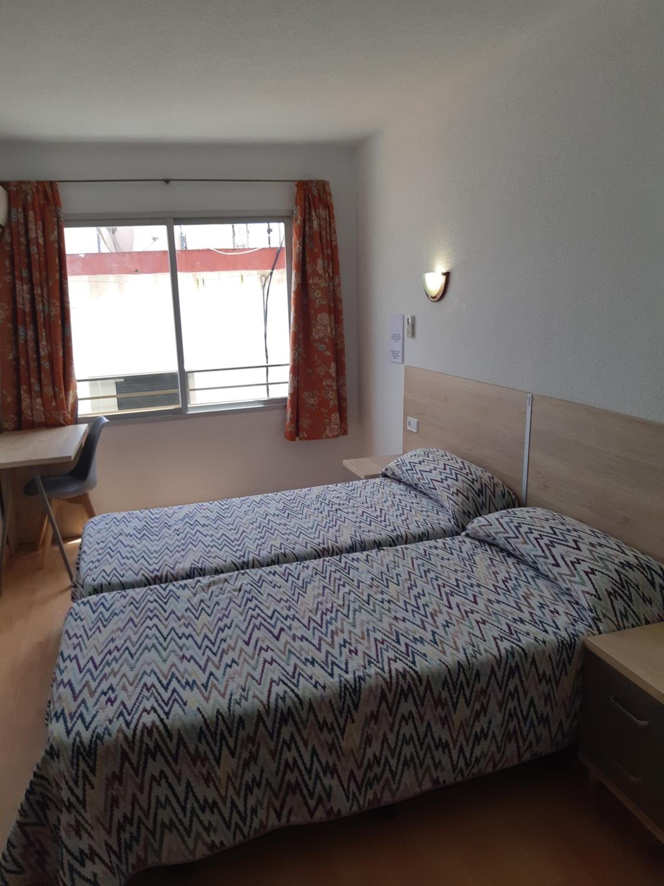 Habitación con dos camas y vista a la calle