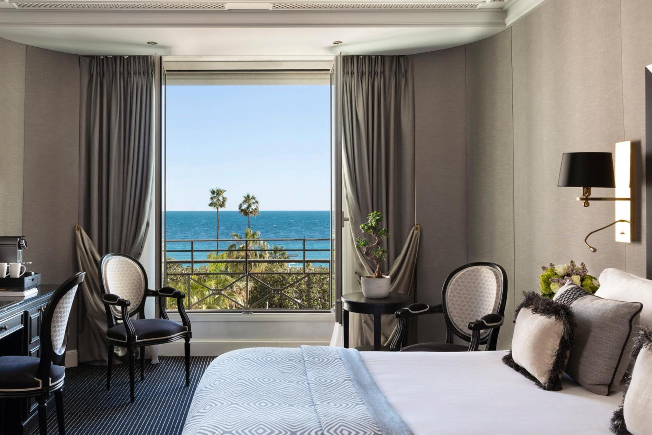 hotel room with a view of the ocean and palm trees