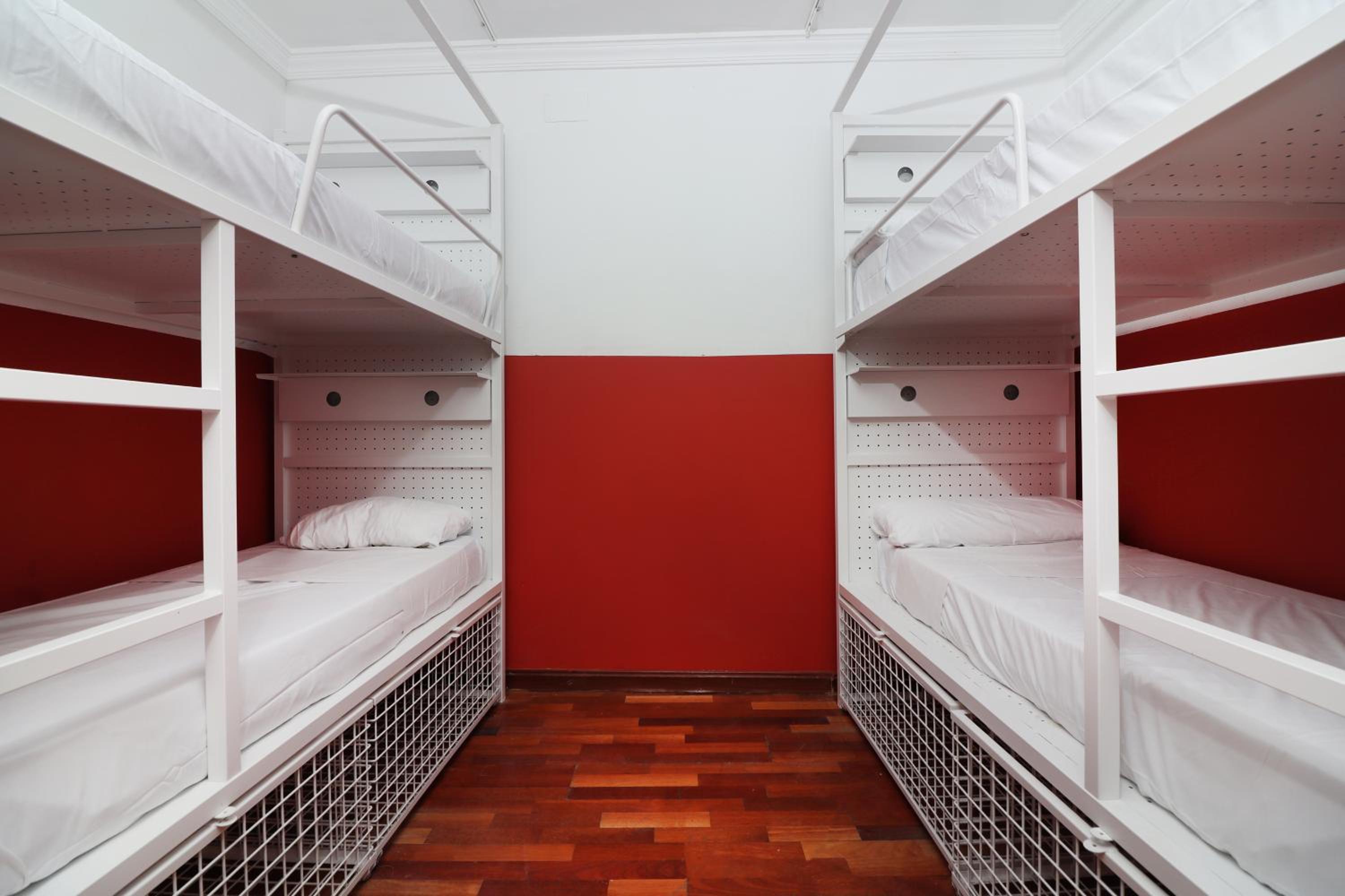 Cama en dormitorio compartido mixto de 8 camas con baño privado.