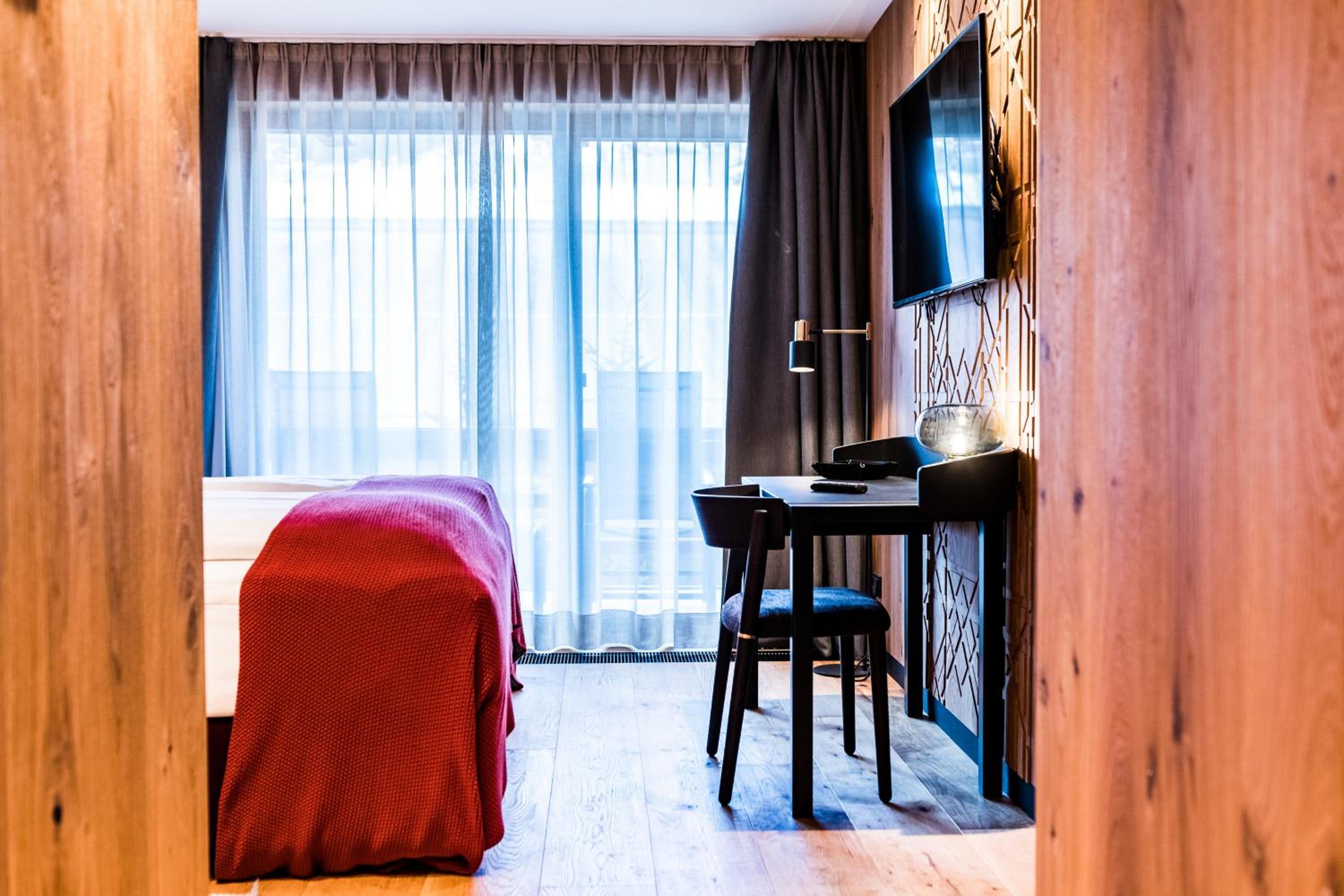 hotel room with a bed, desk, and television