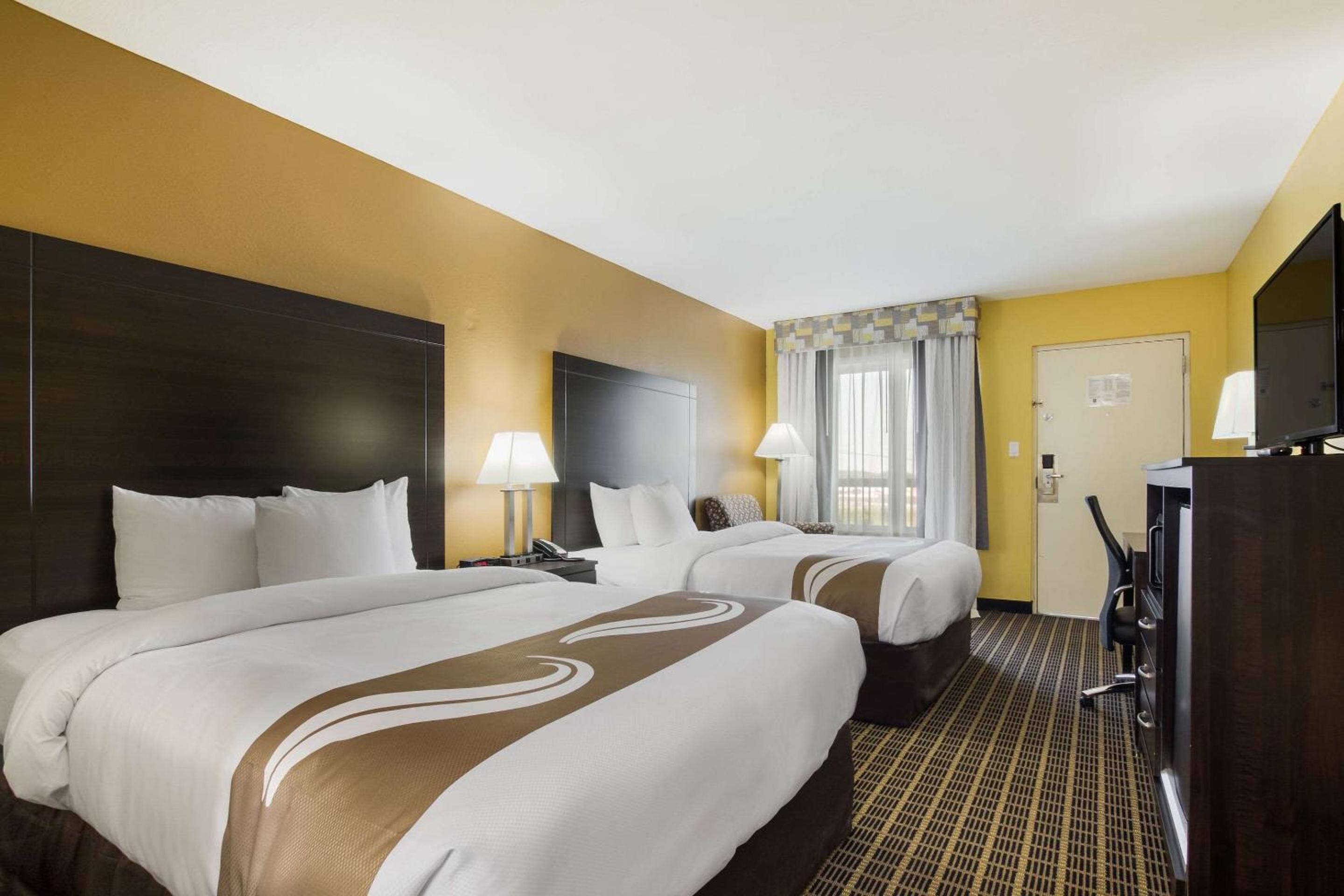 hotel room with two beds and a flat screen tv