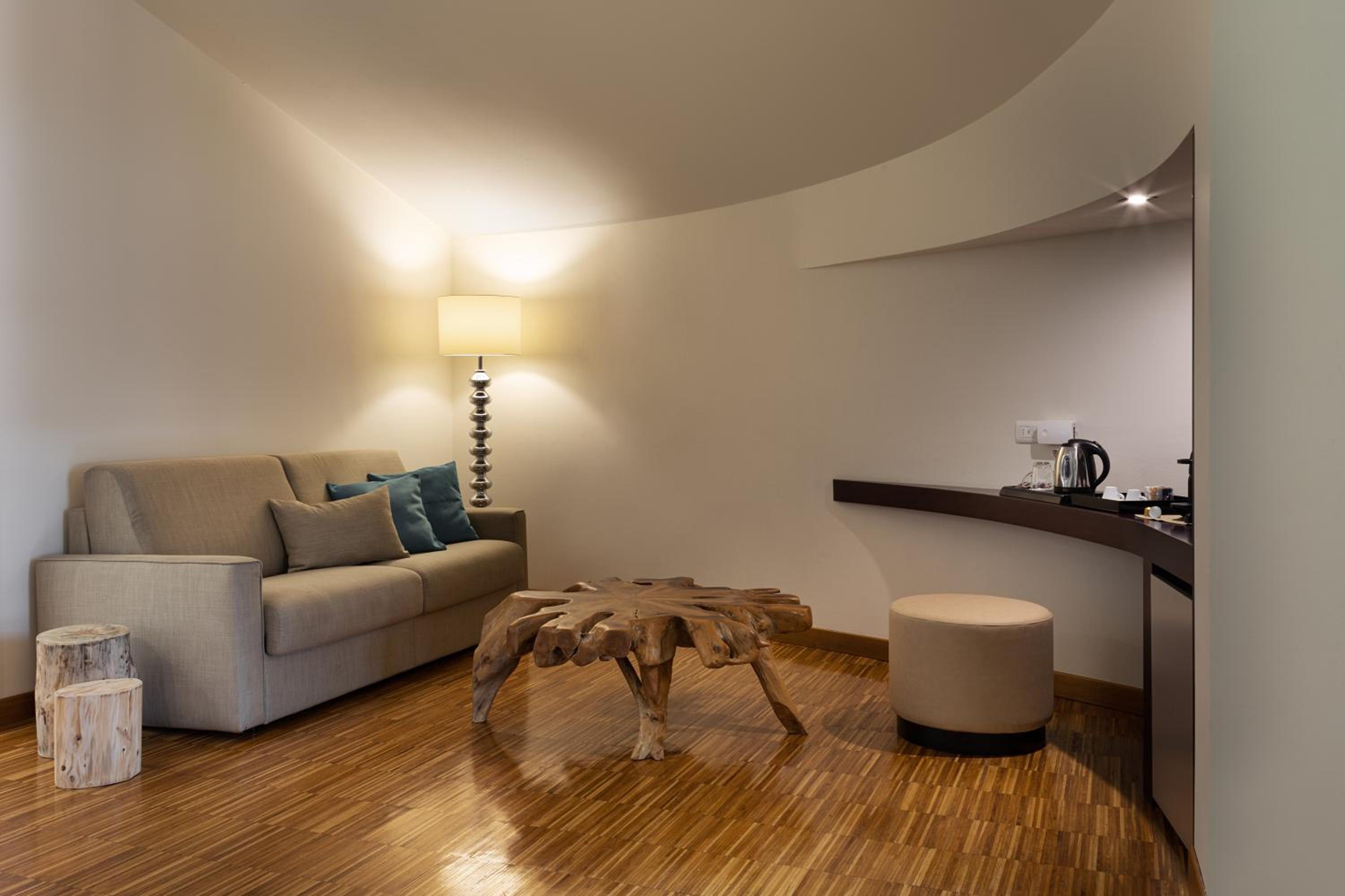 Living area with a beige sofa, rustic wooden coffee table, and wood flooring.