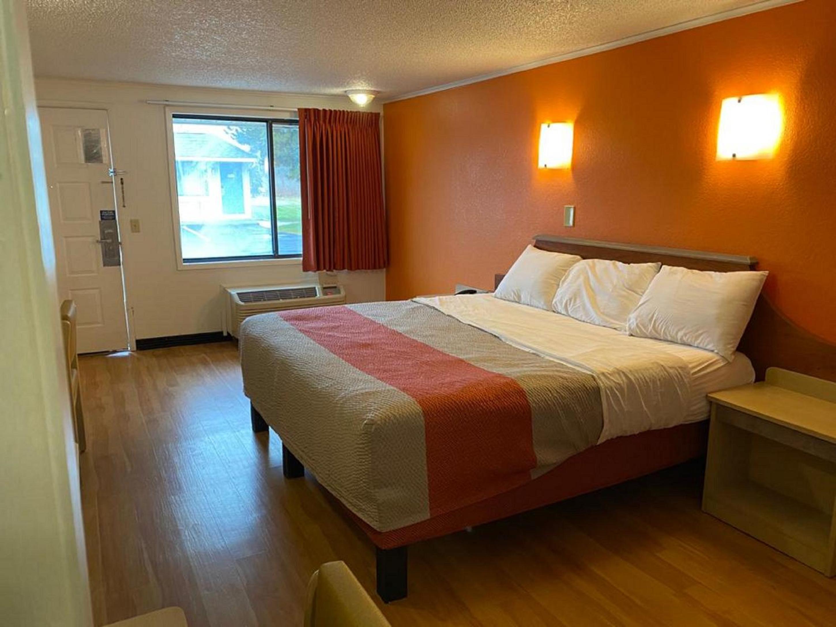 hotel room with a bed, desk, and television
