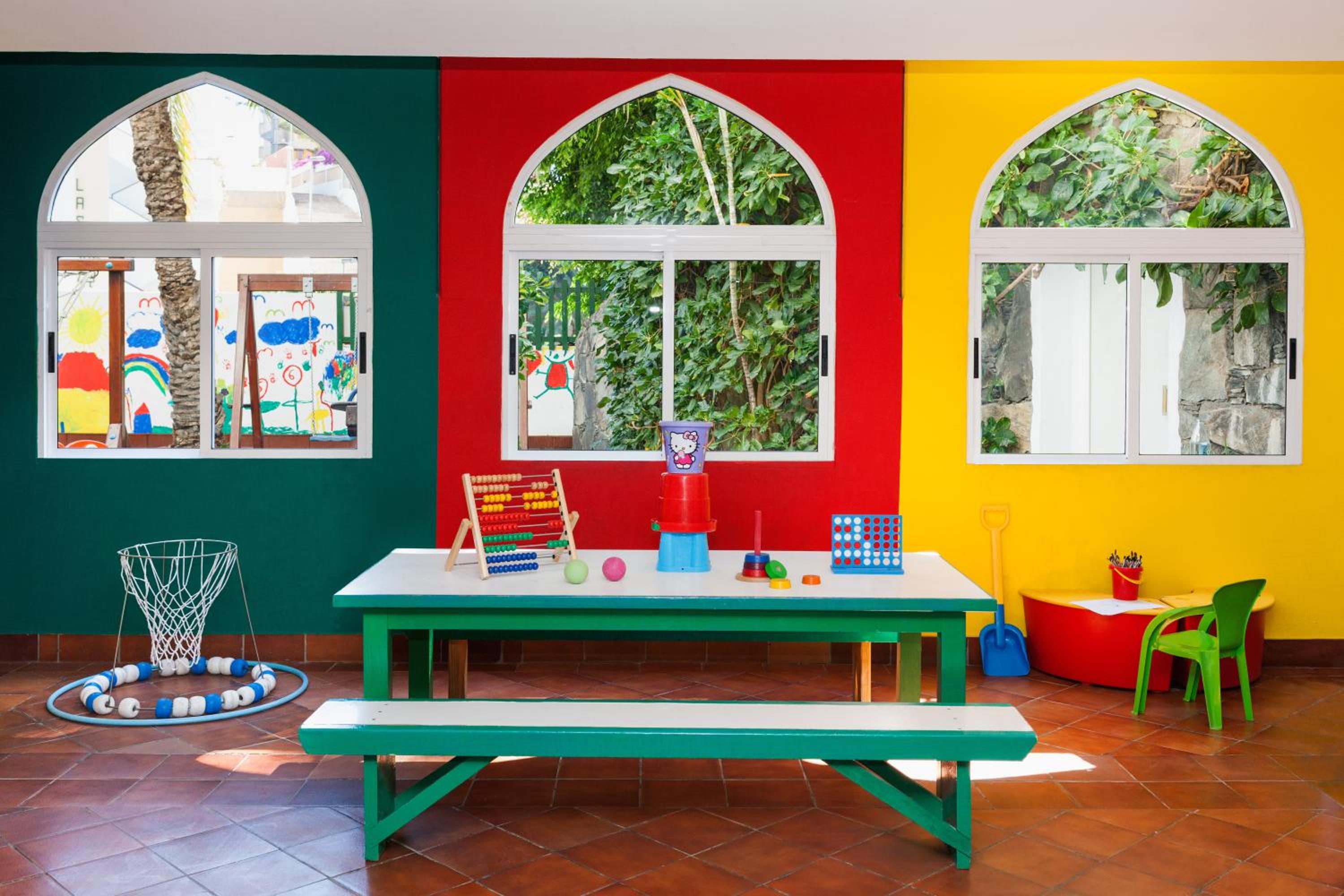 Colorful children's play room with table, toys and arched windows
