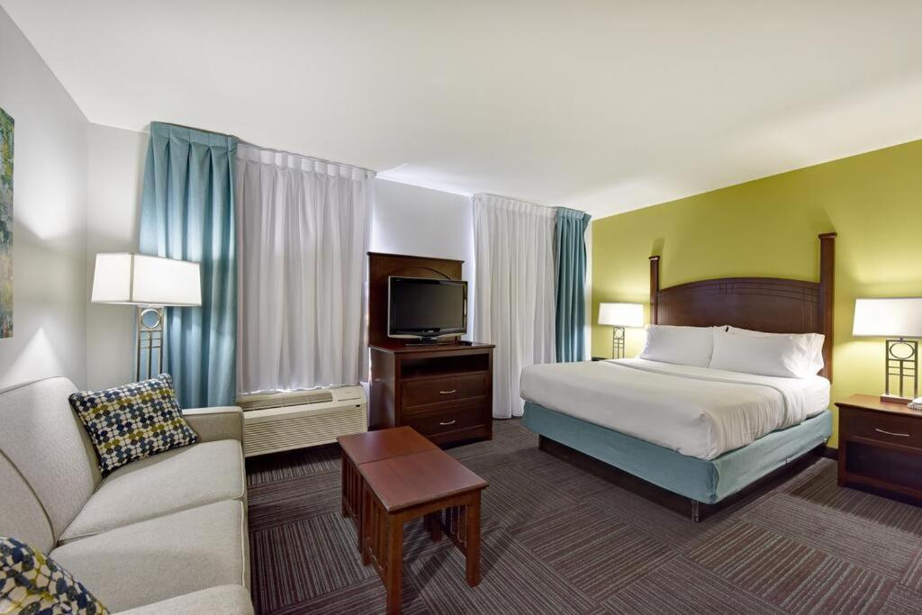 hotel room with a bed, couch, and television