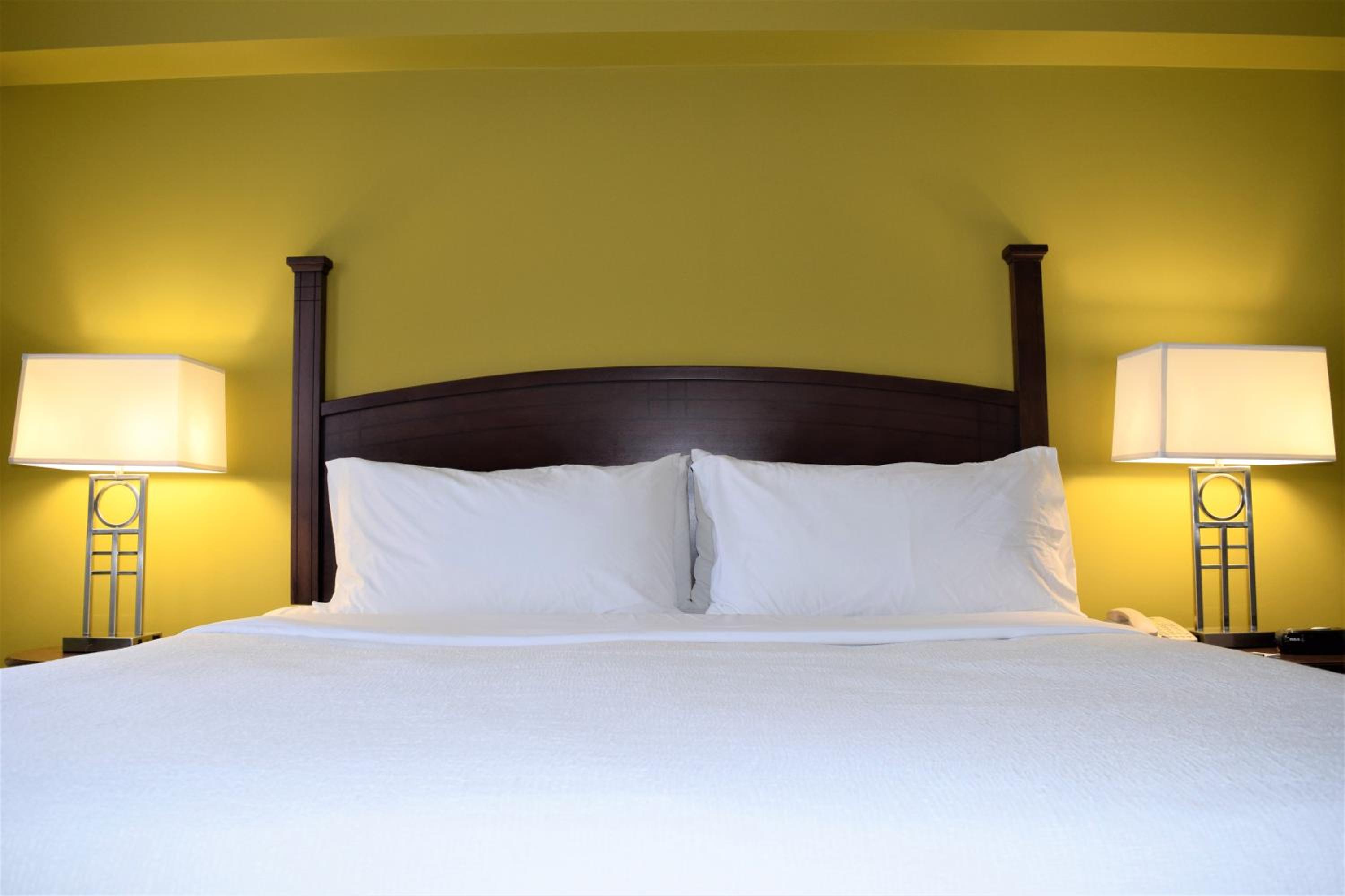 bed with two lamps on either side of the headboard