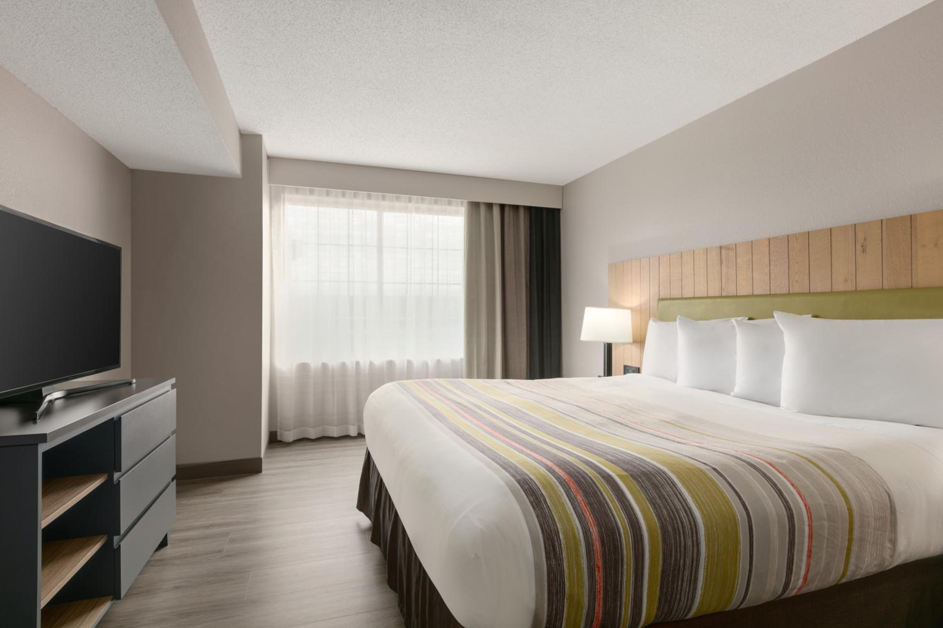 hotel room with a king bed and flat screen tv