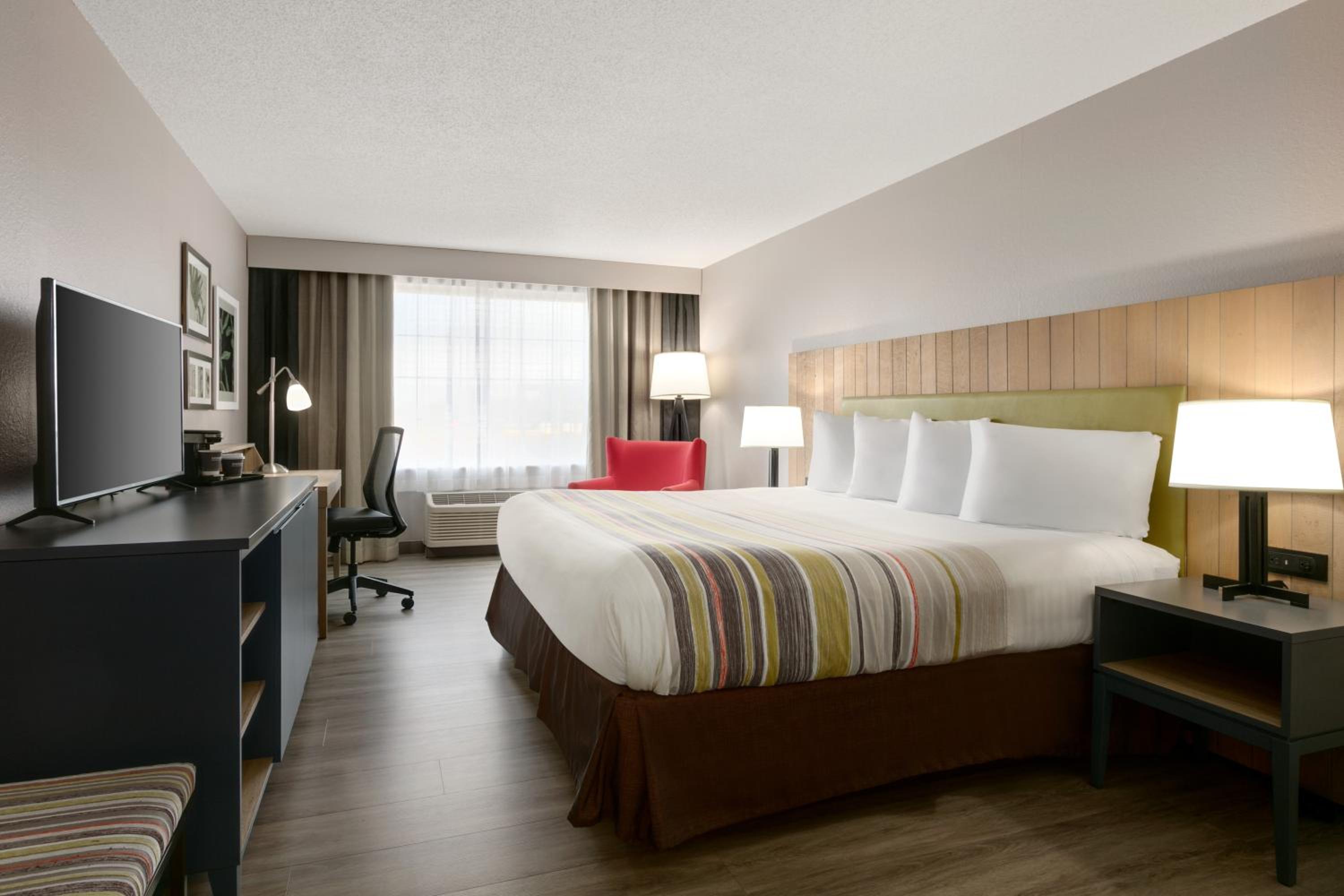 hotel room with a bed, desk, and television