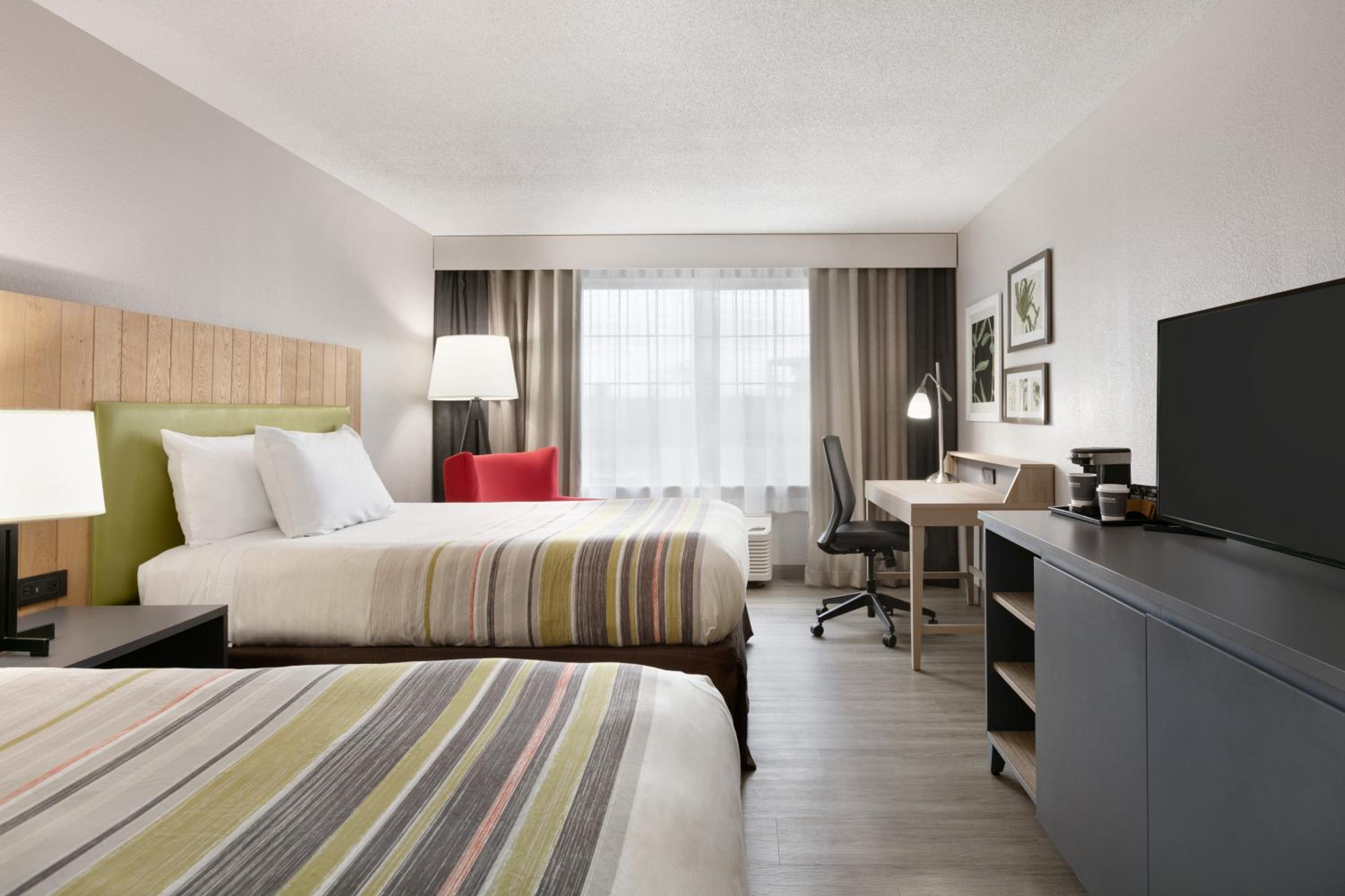 hotel room with two beds and a flat screen tv