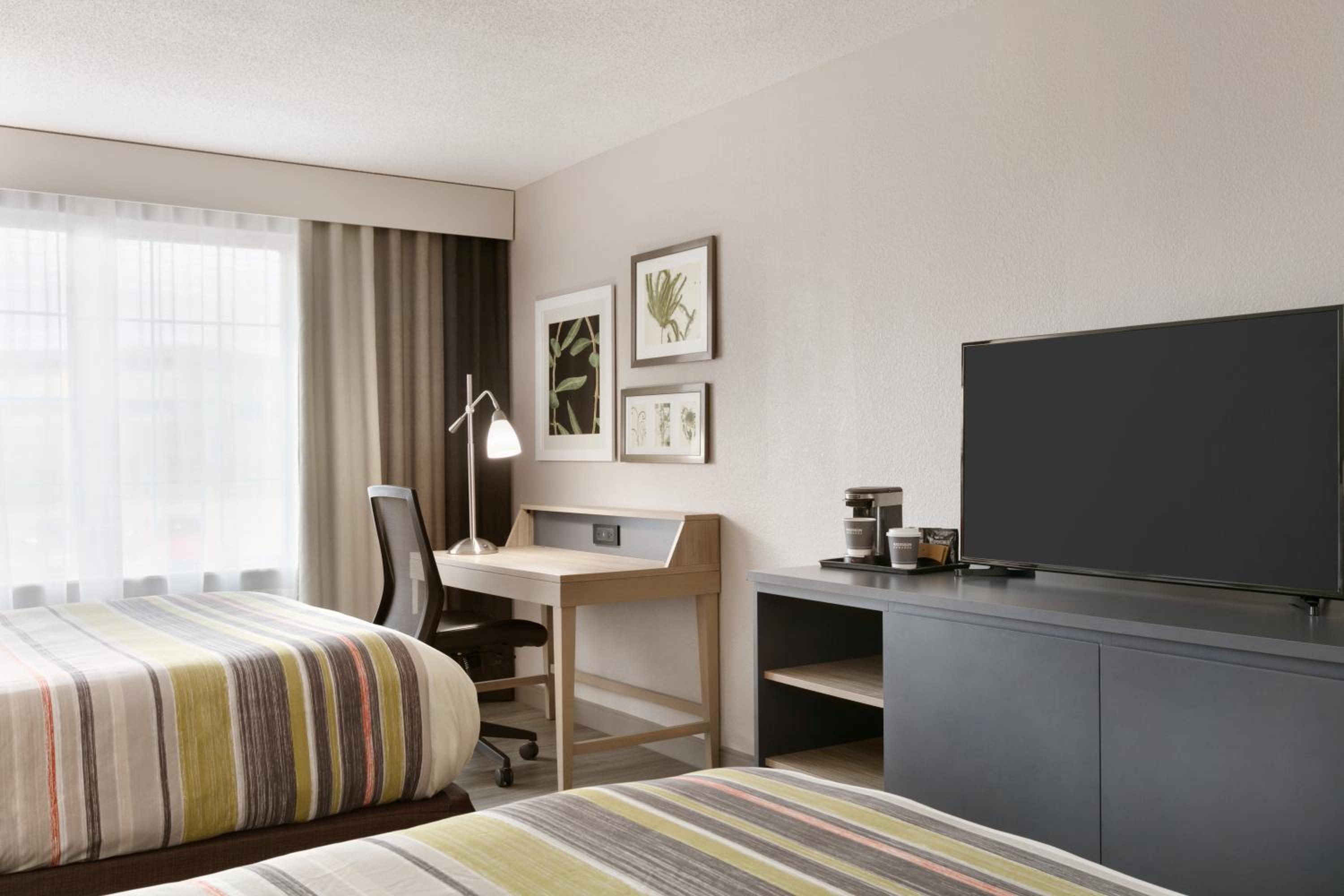 hotel room with two beds and a flat screen tv
