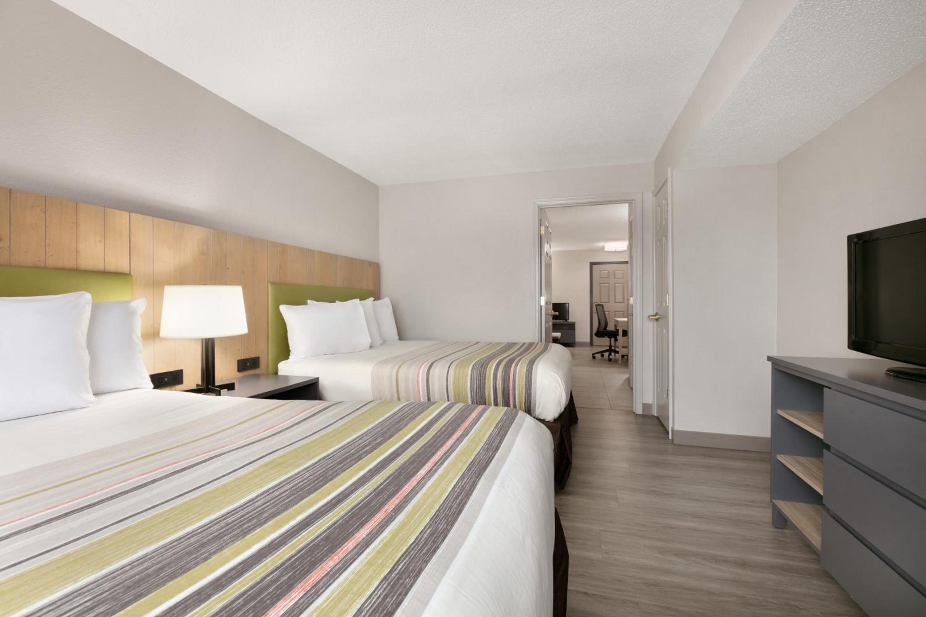 hotel room with two beds and a flat screen tv