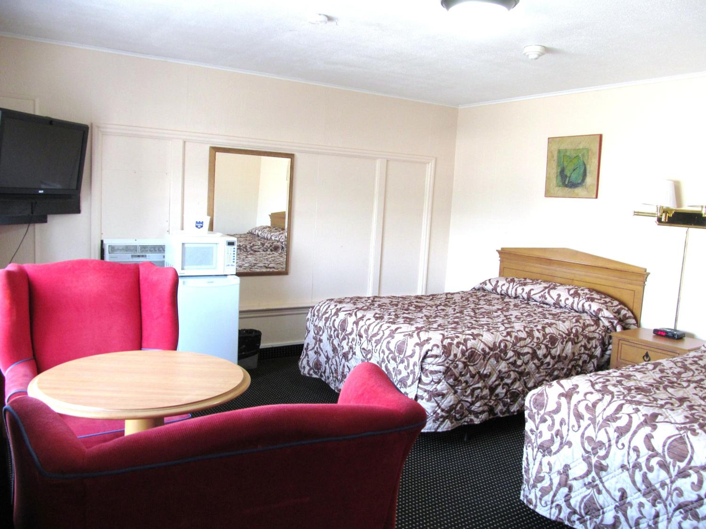 hotel room with two beds and a small kitchenette