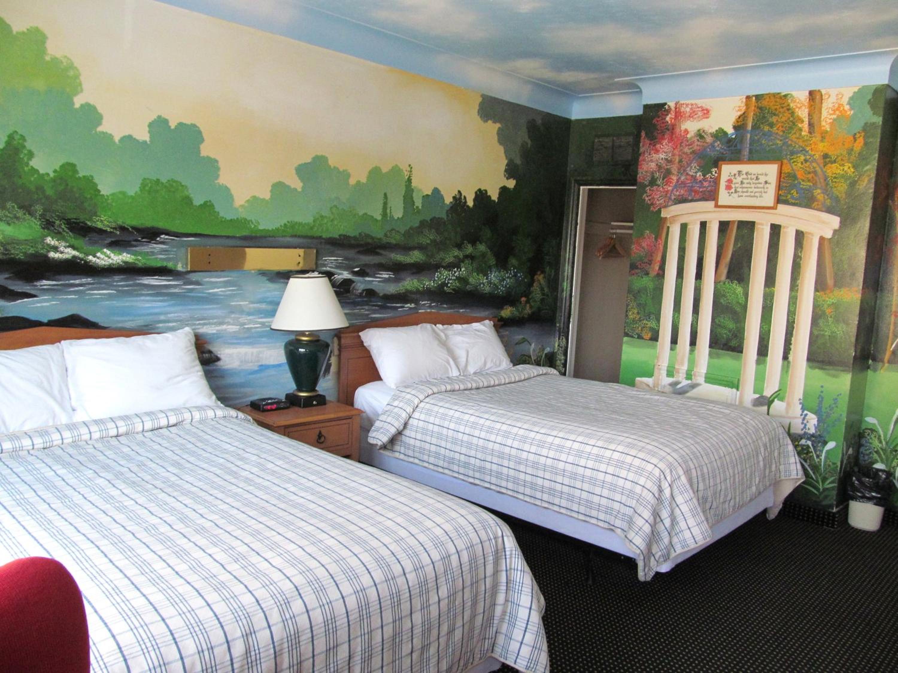 bedroom with two beds and a painting on the wall