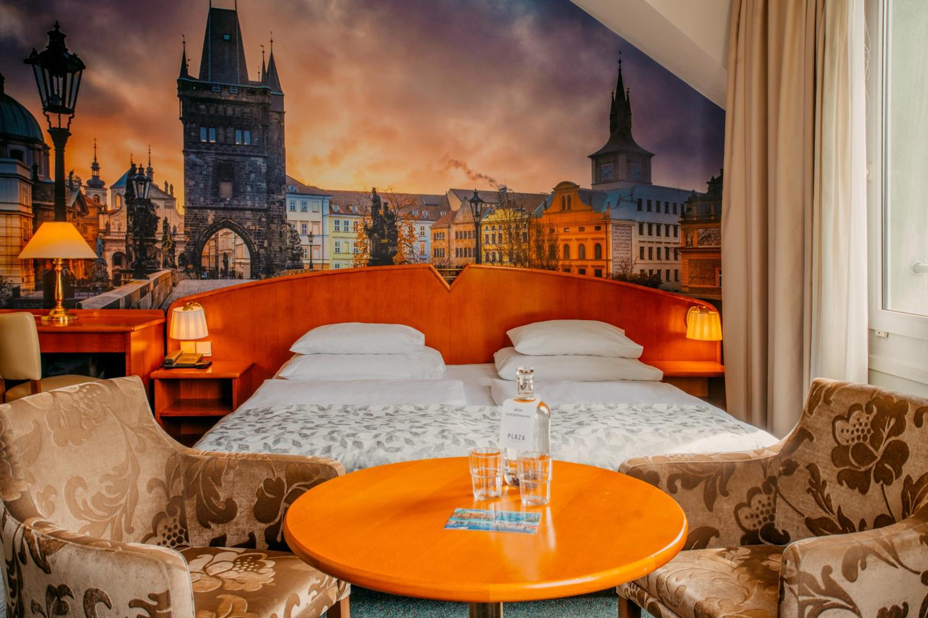 Hotel room with a double bed, orange headboard, and a large cityscape mural.