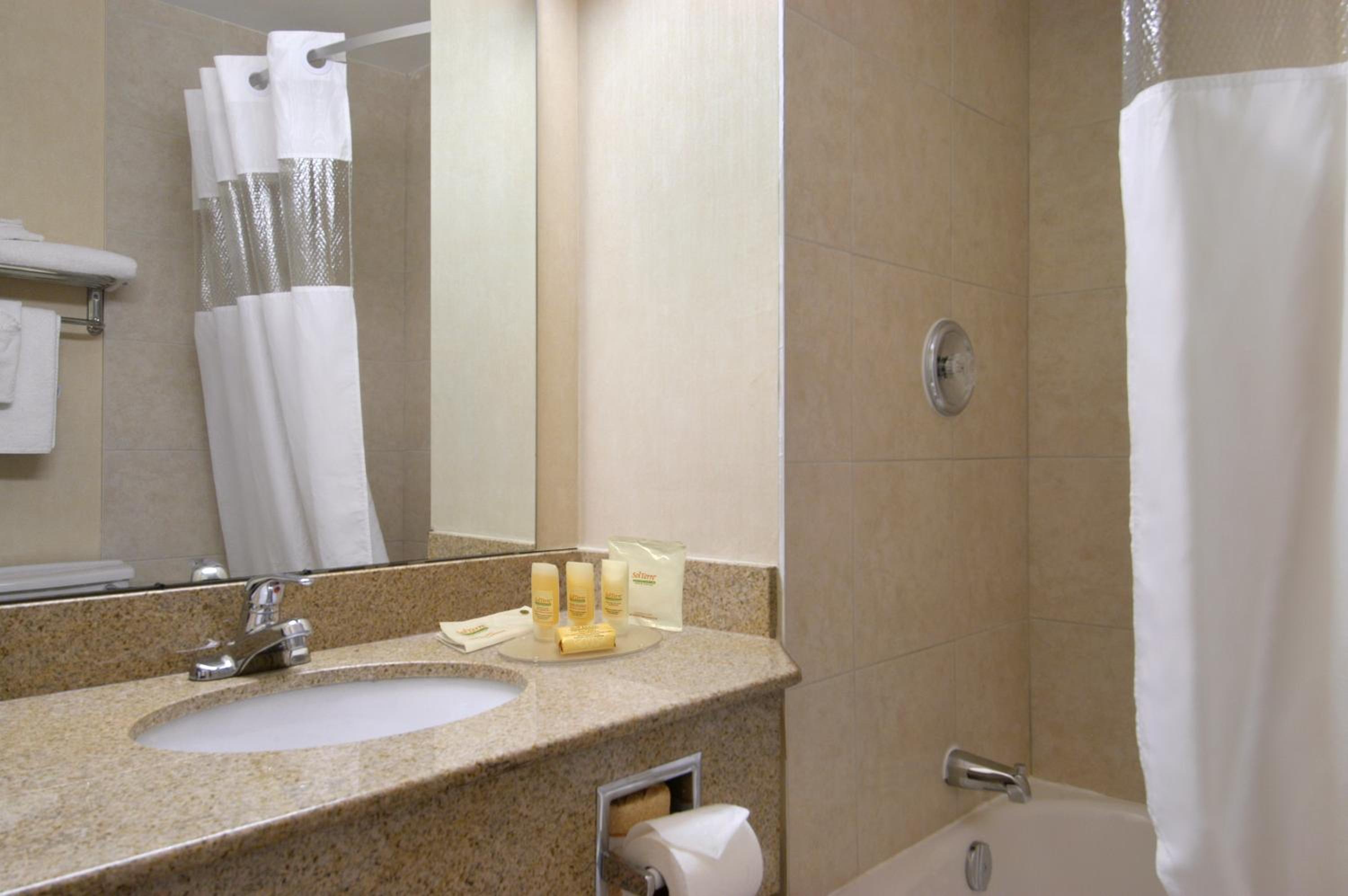bathroom with a bathtub, sink, and shower curtain
